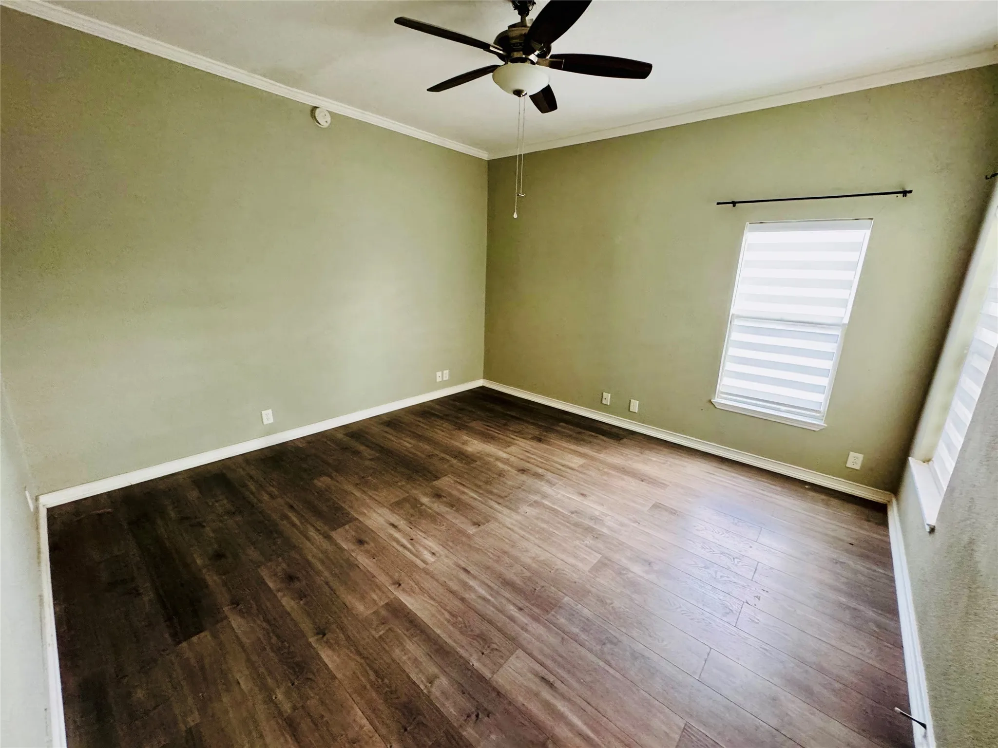Bright, cozy living space with ceiling fan