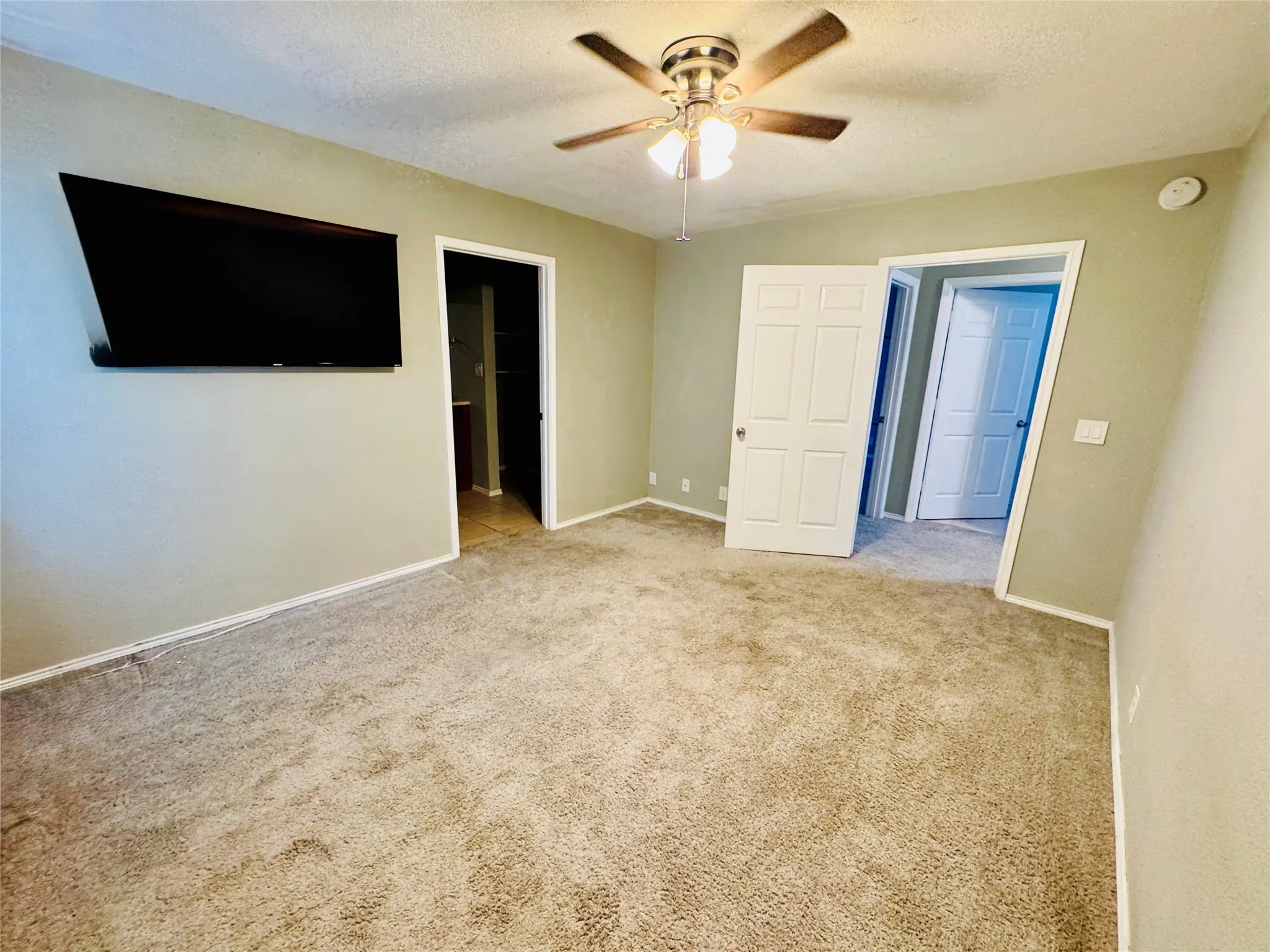 Spacious bedroom with ceiling fan and ensuite bathroom