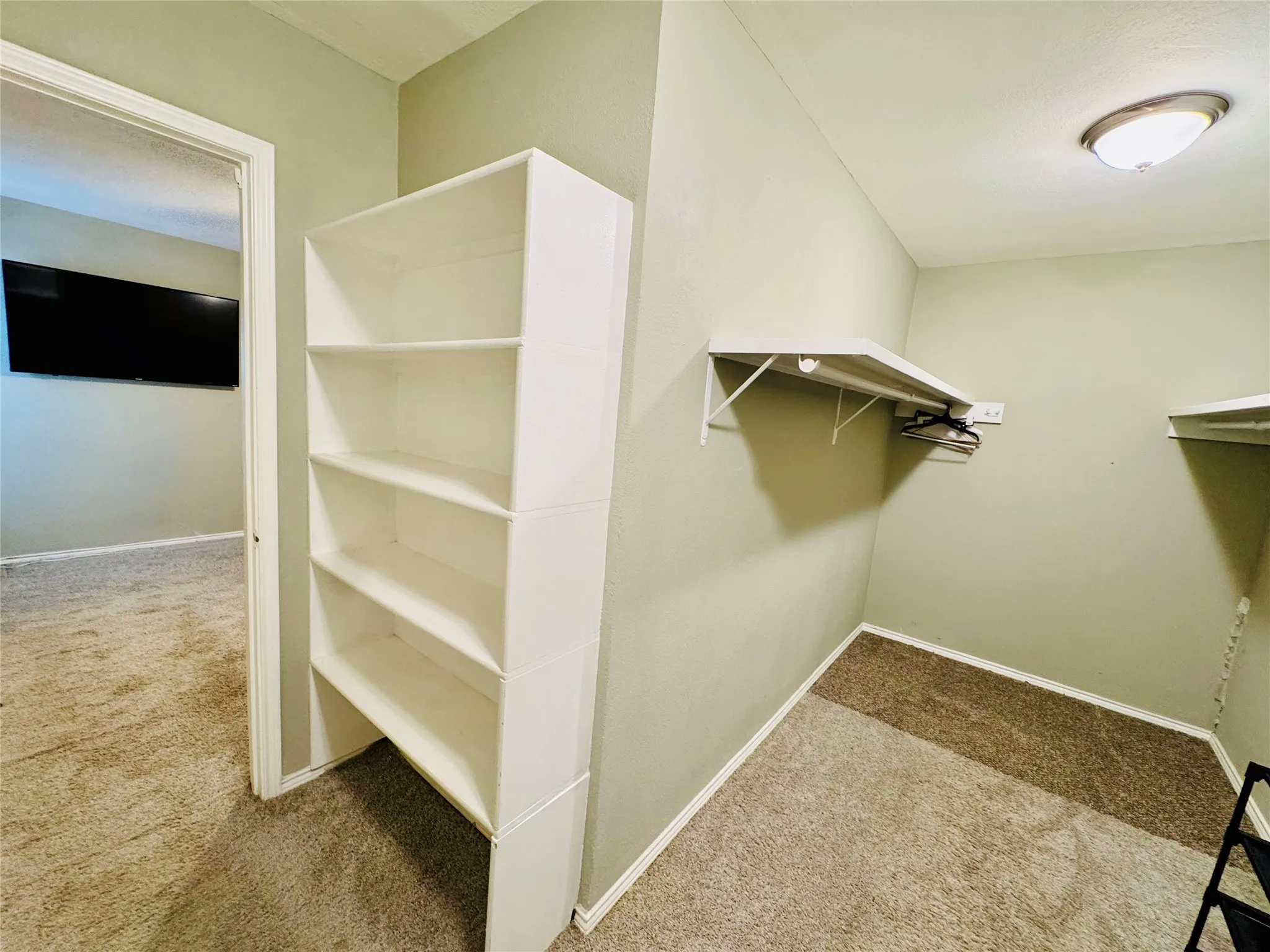 Spacious walk-in closet with shelving
