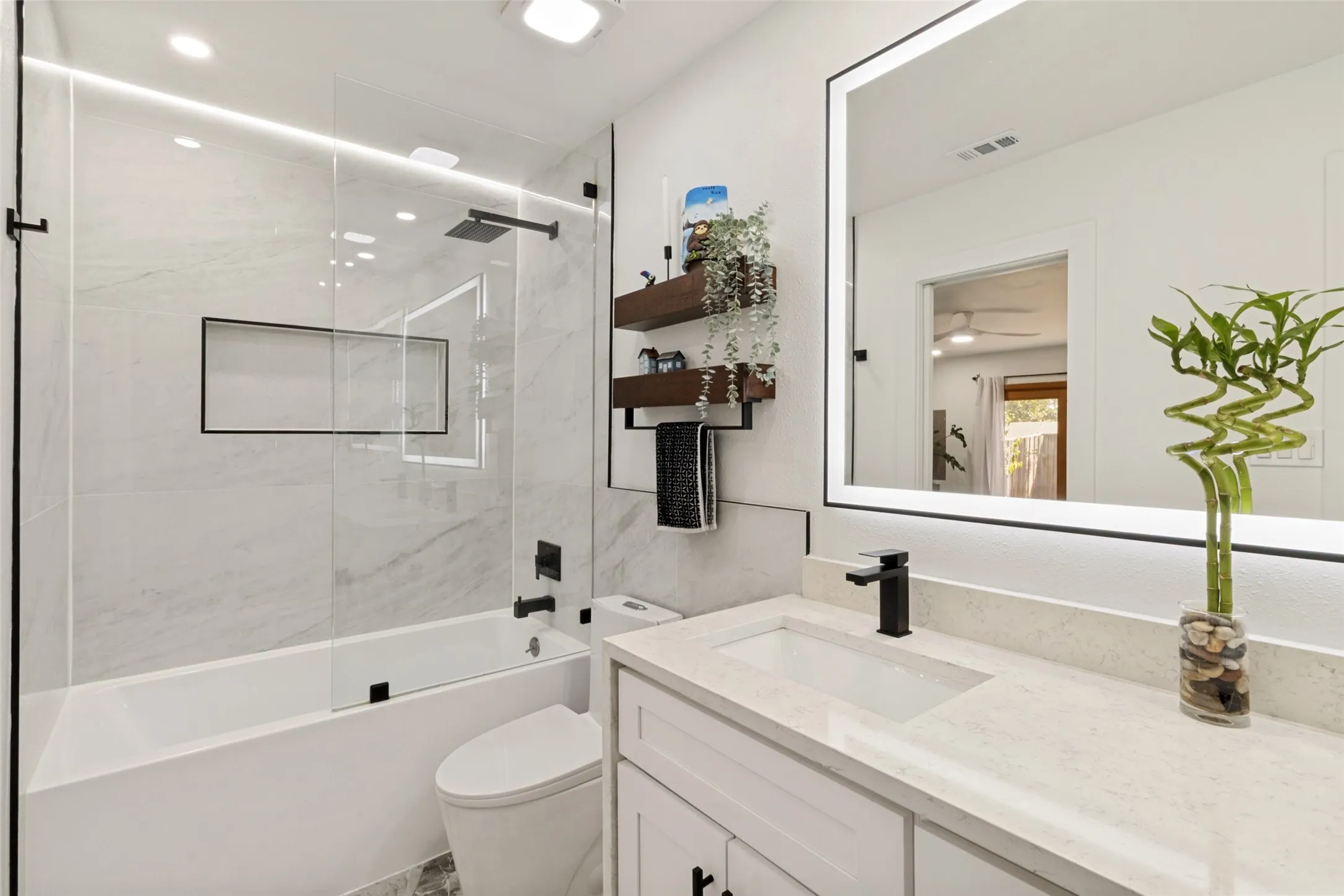 White vanity with integrated sink and matte black faucet