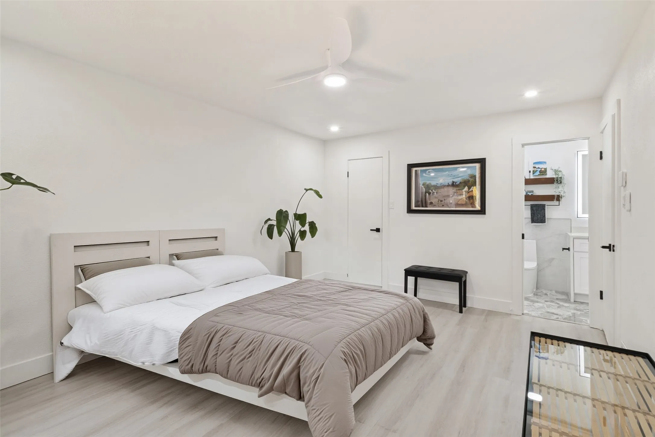 Wood-finish flooring, recessed lighting, ceiling fan, and access to a bathroom with a vanity and wall-mounted mirror