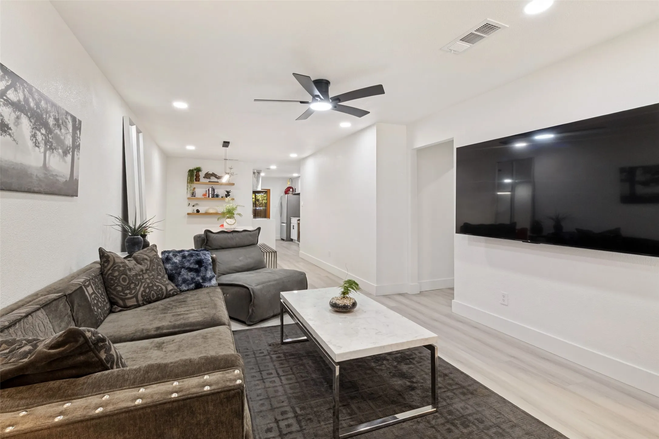 Recessed lighting, wood-finish flooring, and a contemporary ceiling fan
