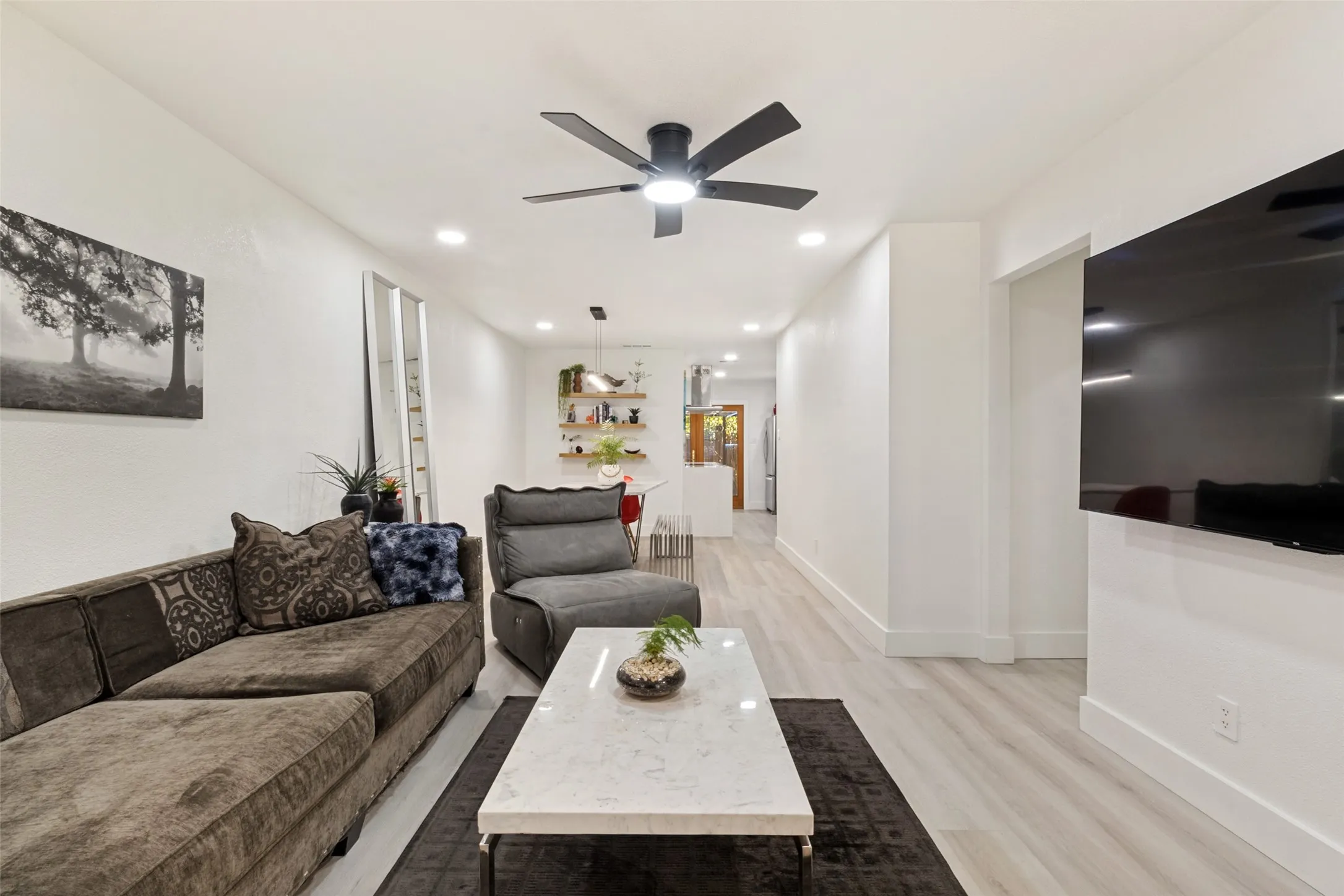 Recessed lighting, wood-finish flooring, and a contemporary ceiling fan