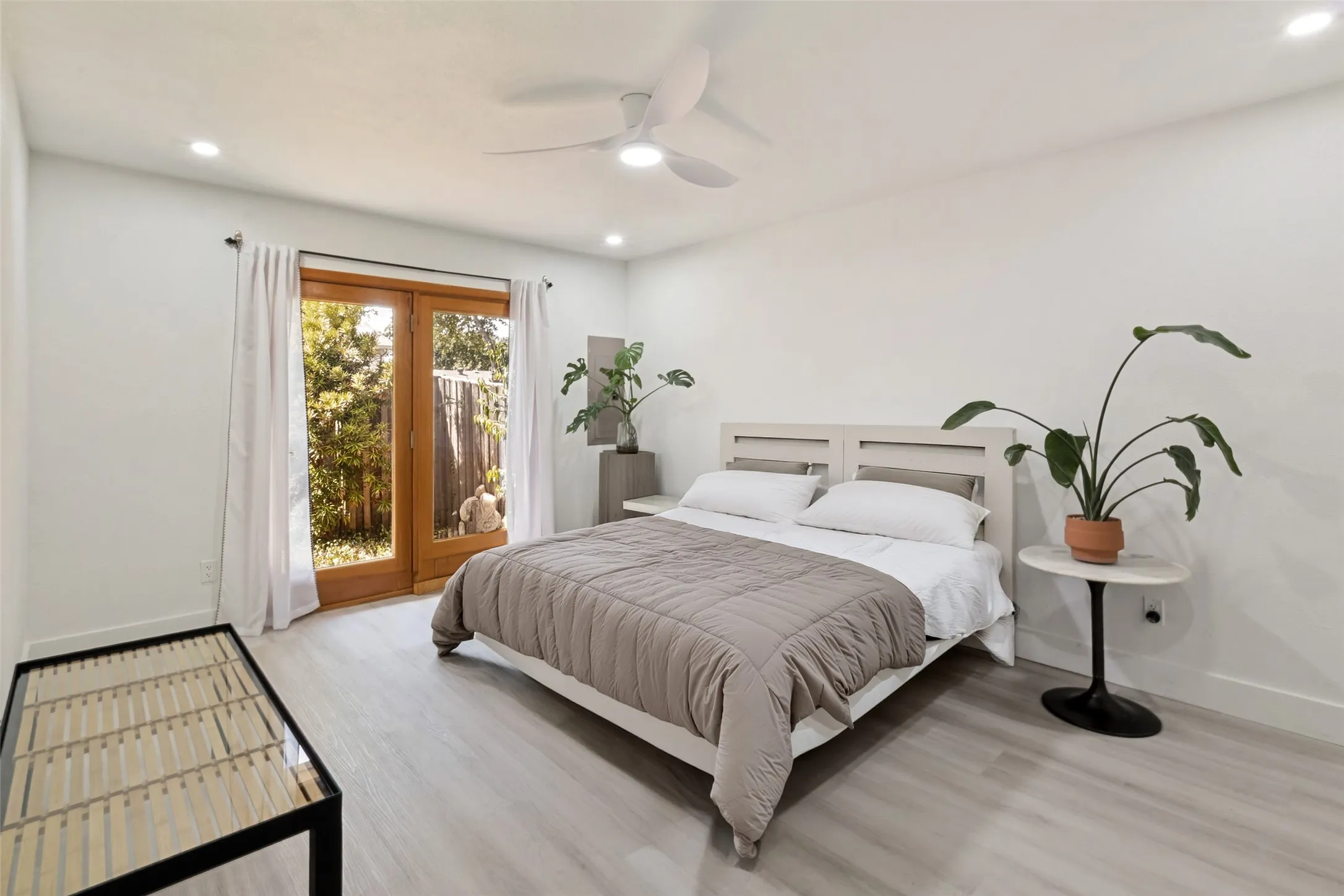 Recessed lighting, light wood-finish flooring, white walls, ceiling fan, and double wood-frame doors