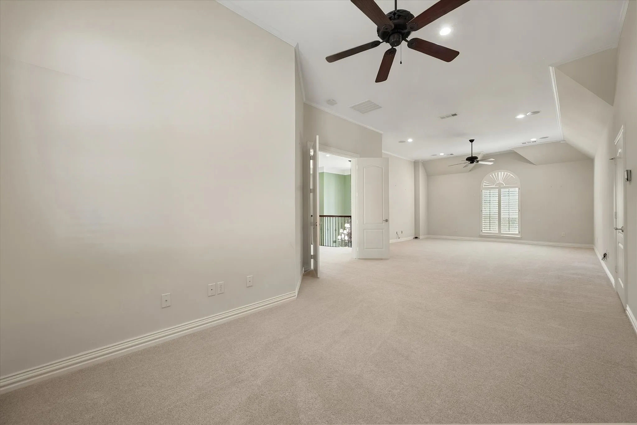 Expansive carpeted room featuring vaulted ceilings, recessed lighting, and multiple ceiling fans