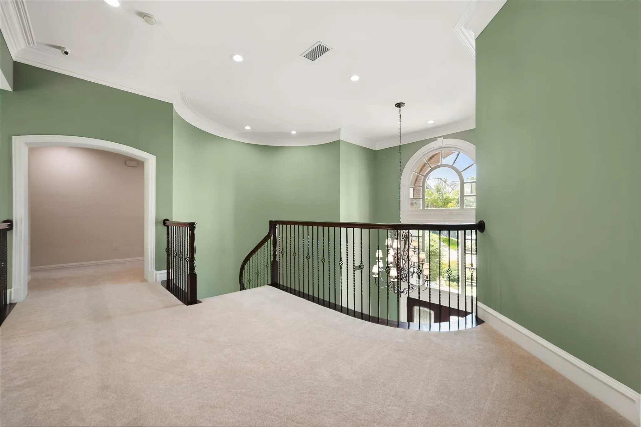 Upstairs landing, recessed lighting, decorative iron balusters, arched window with a view of the peaceful​​‌​​​​‌​​‌‌​‌‌​​​‌‌​‌​‌​‌​​​‌​​ surroundings