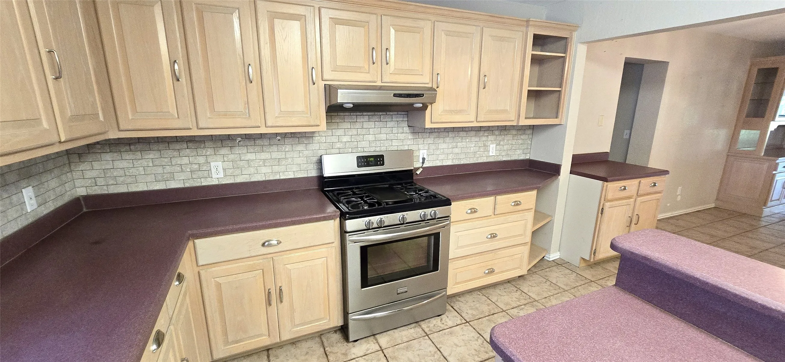 Wood-finish cabinetry paired with a tile backsplash