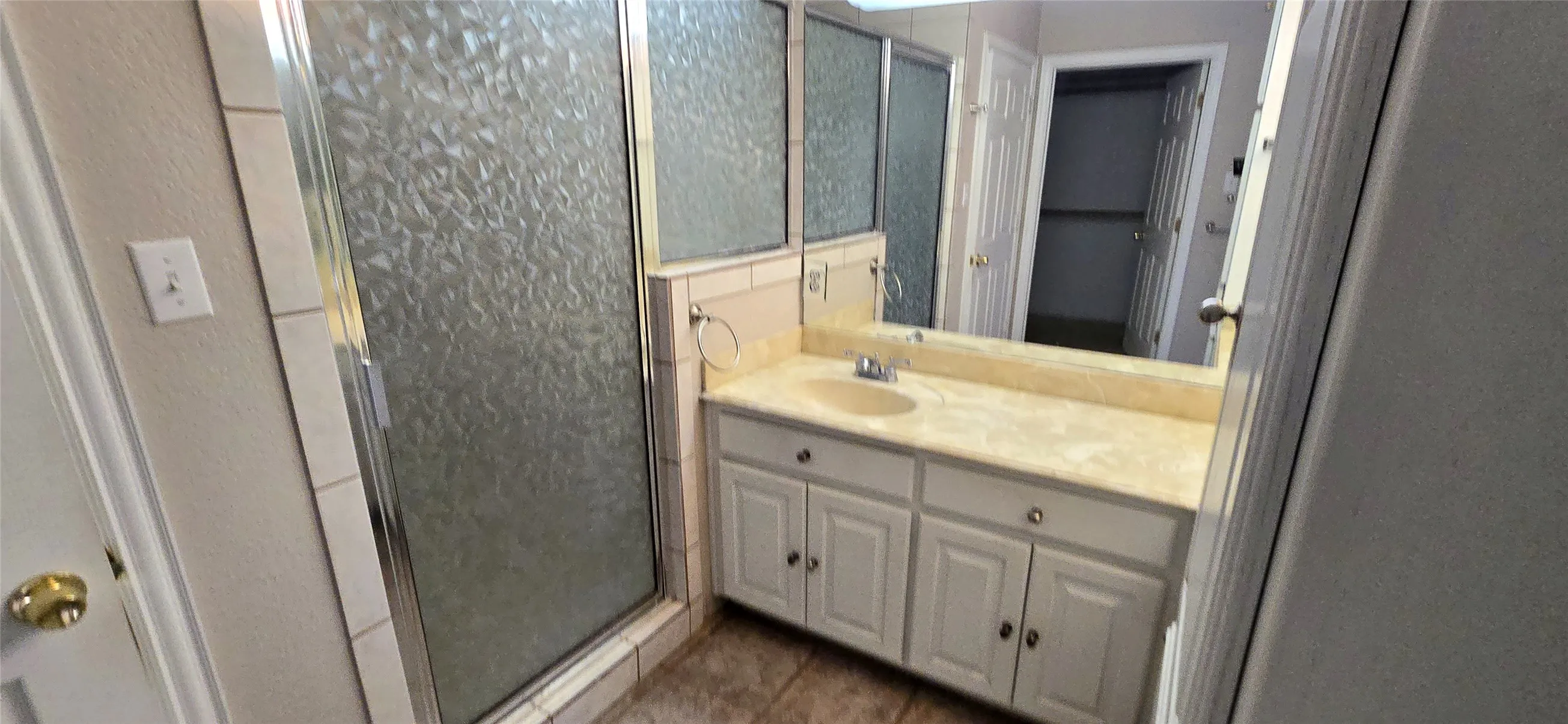 Vanity with integrated sink, panel cabinetry, and wall-mounted mirror