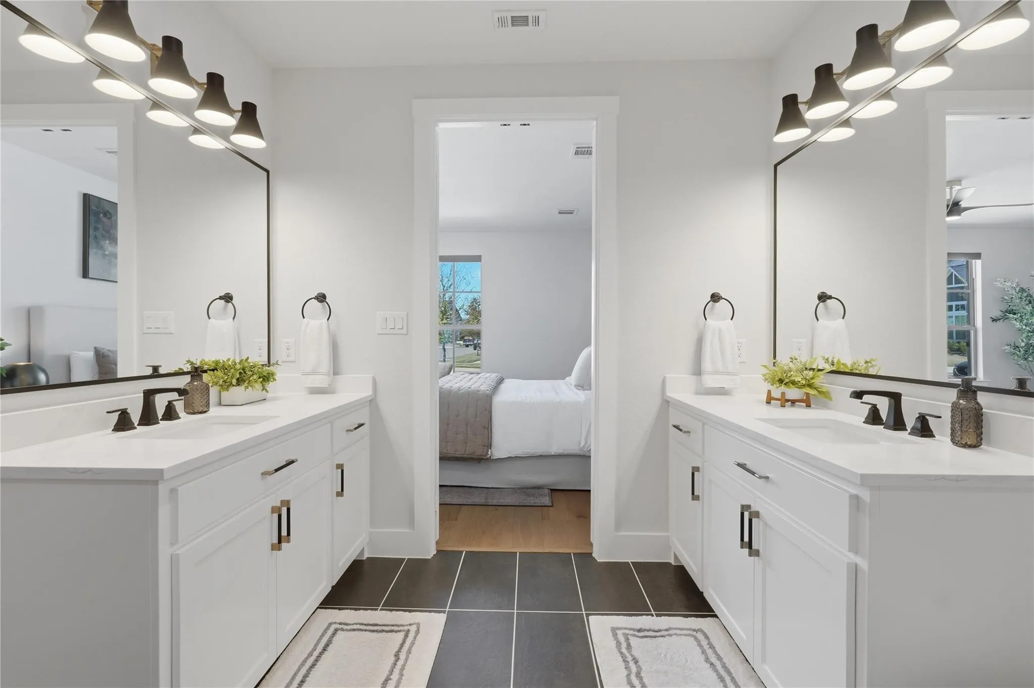 Dual white vanities with integrated sinks, matte black faucets, and rectangular mirrors