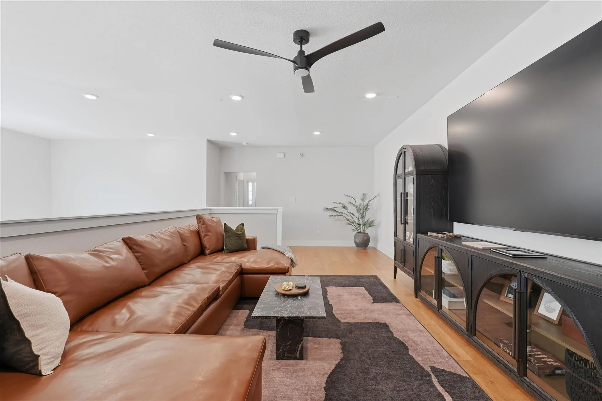 Hardwood-finish flooring, recessed lighting, and a modern ceiling fan