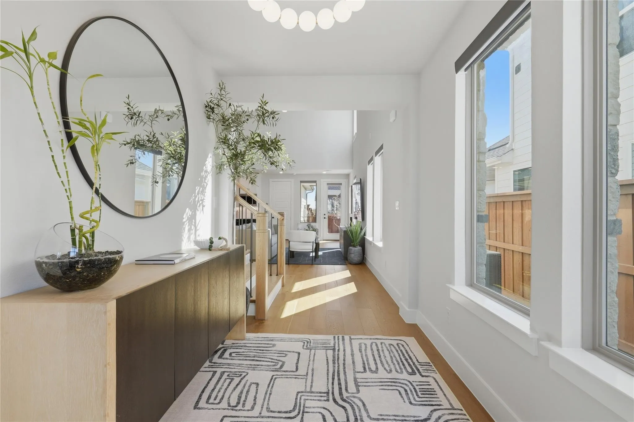 Hardwood flooring, recessed lighting, and a contemporary light fixture complement the bright interior