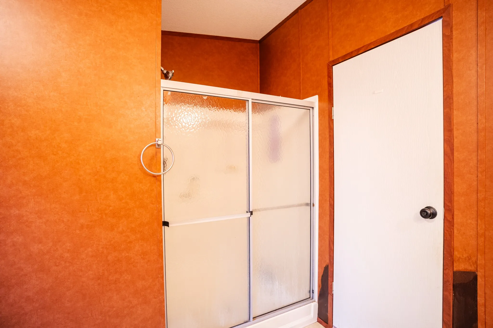 Shower enclosure with frosted sliding doors and a white base