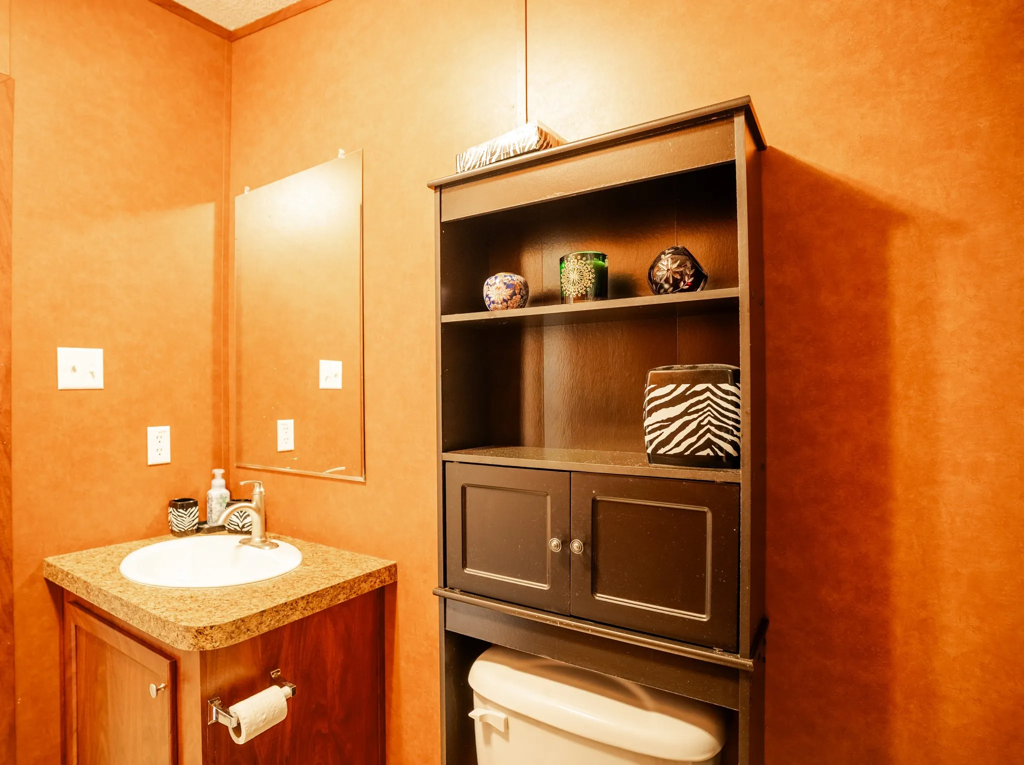 Vanity with an integrated sink, a dark wood-finish cabinet, and a complementing countertop