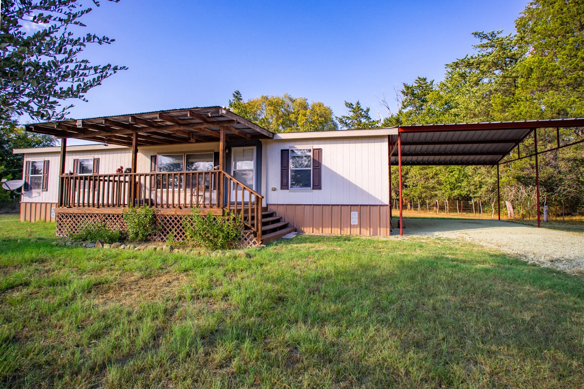 Front porch with wood railing and steps, covered by a wood-slat pergola