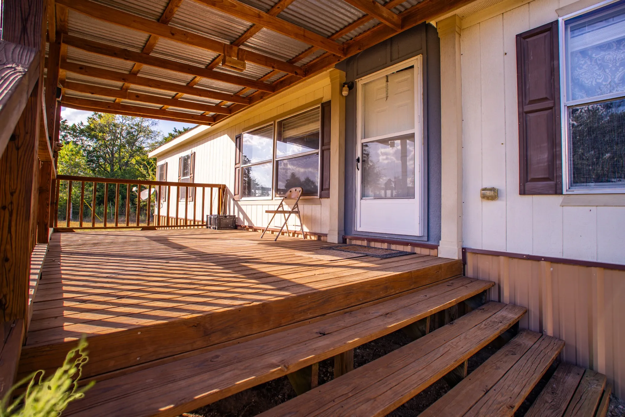 Covered wood-finish porch with a corrugated metal roof