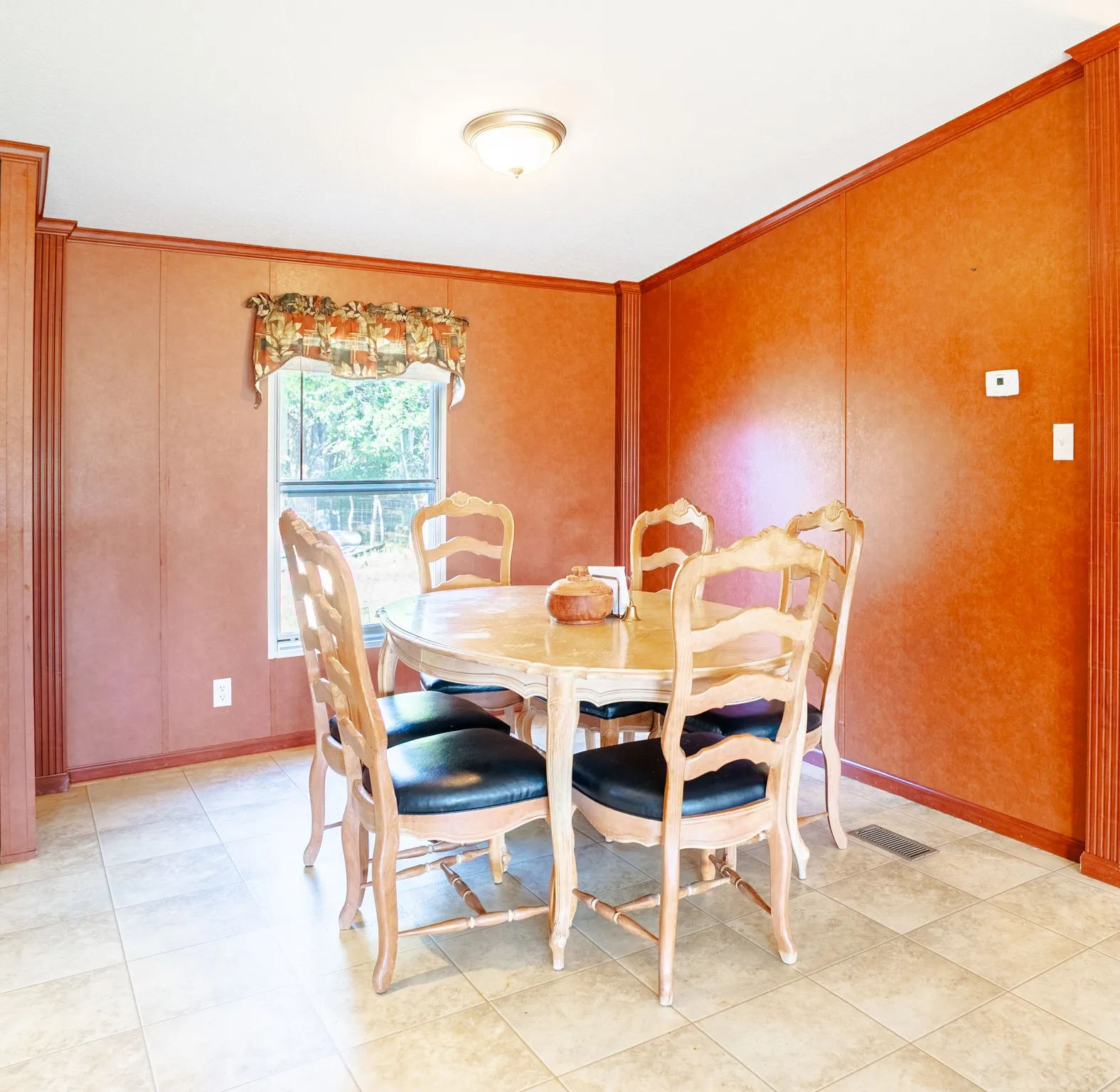 Recessed window, crown molding, chair rail molding, ceiling-mounted light fixture, and tile flooring