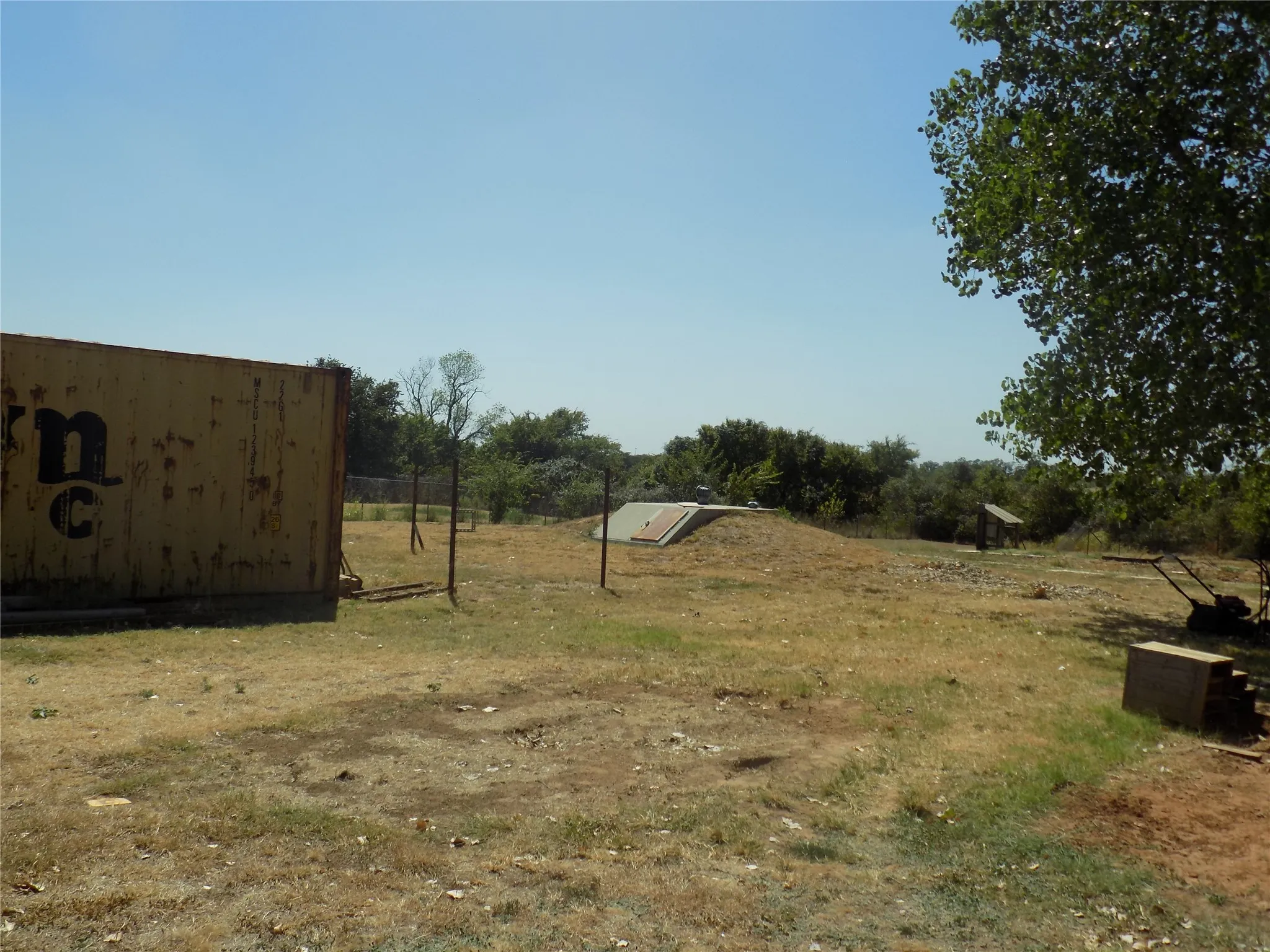16 person in-ground storm shelter showing in background.