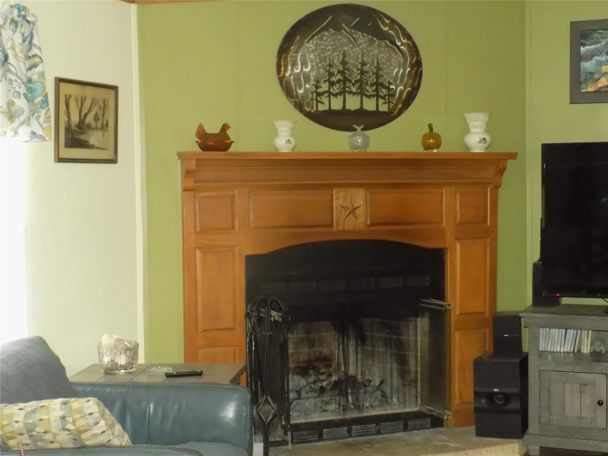 Closer view of carved wooden framed fireplace with mantel.