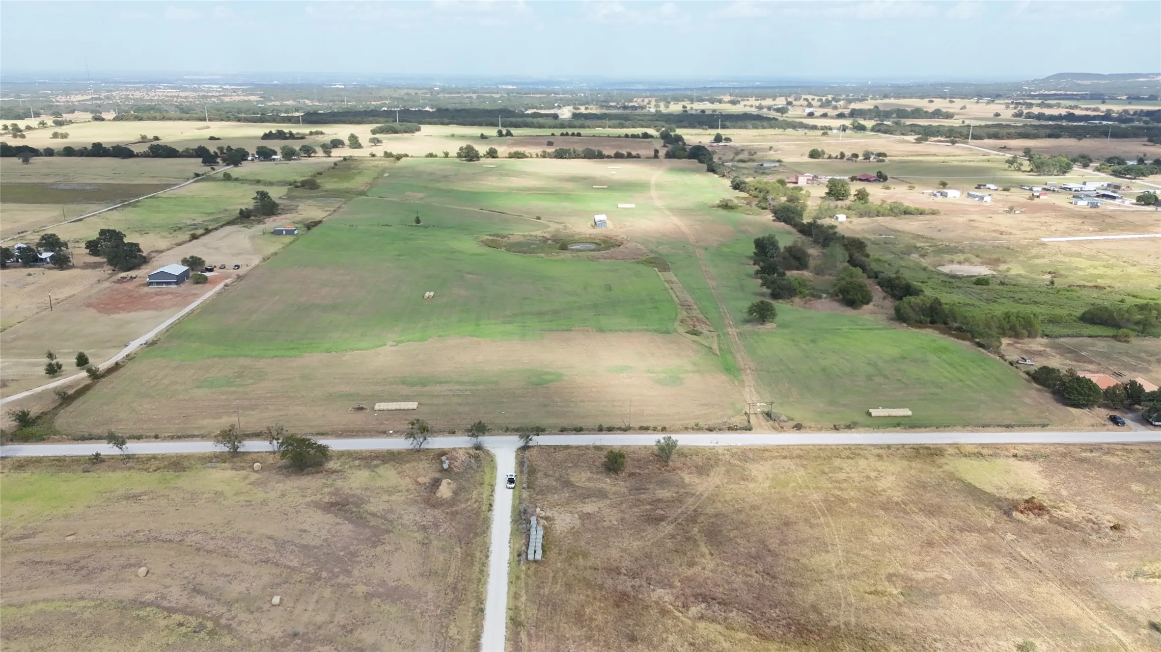 Expansive rural landscape featuring a mix of open fields and scattered trees