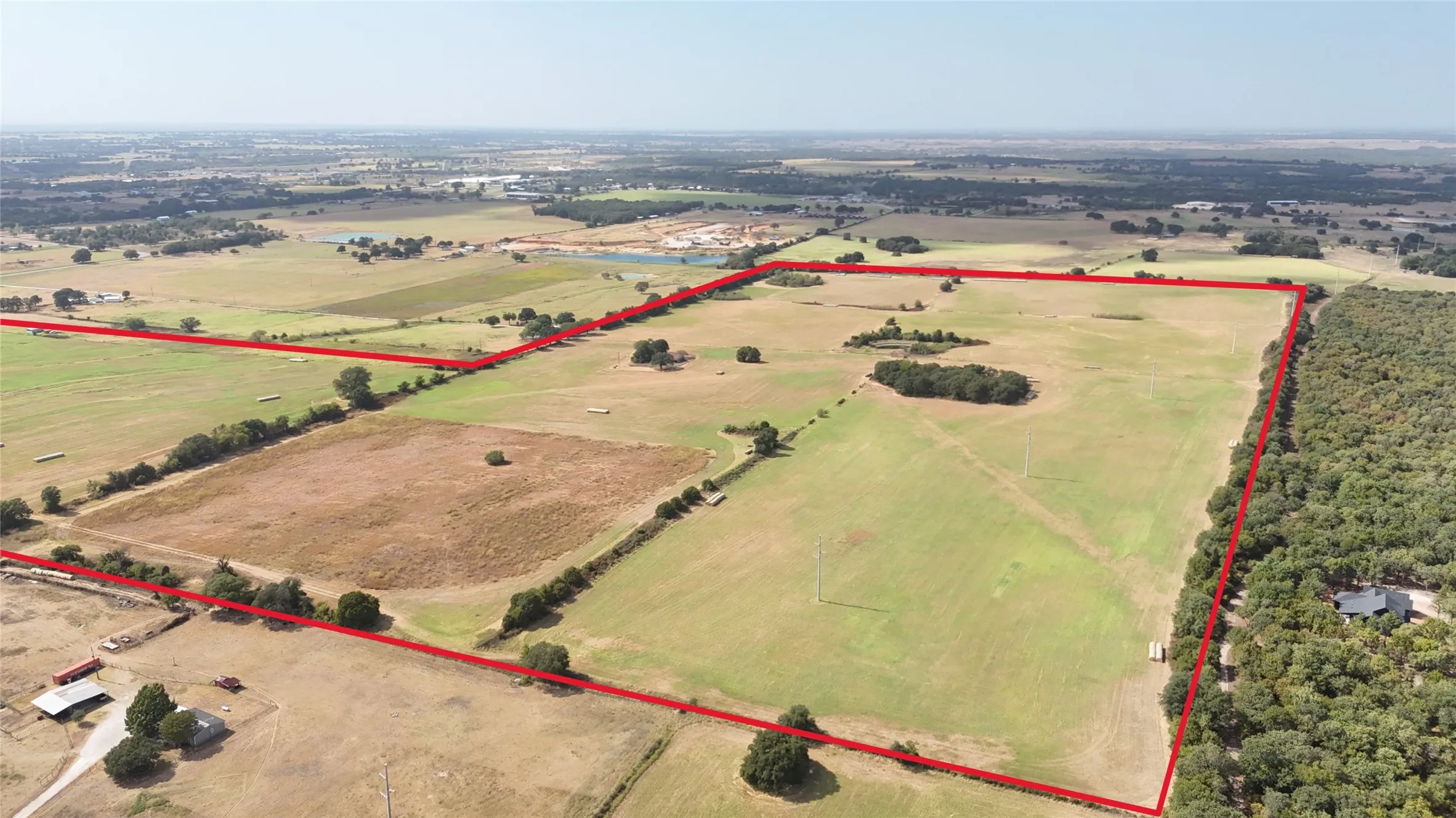 Expansive acreage featuring cleared land, mature trees, and a pond