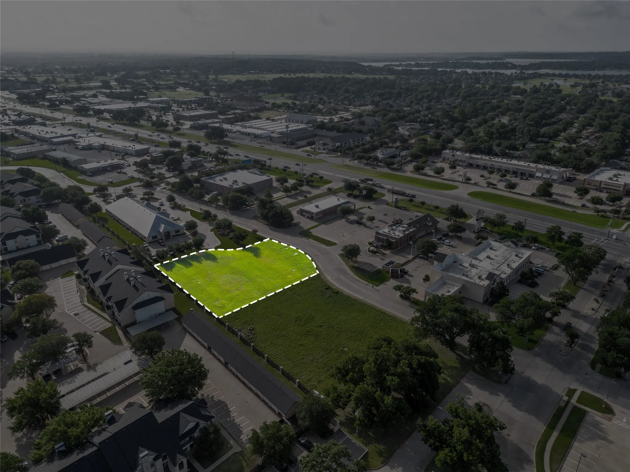 Expansive grassy lot bordered by established trees and road frontage