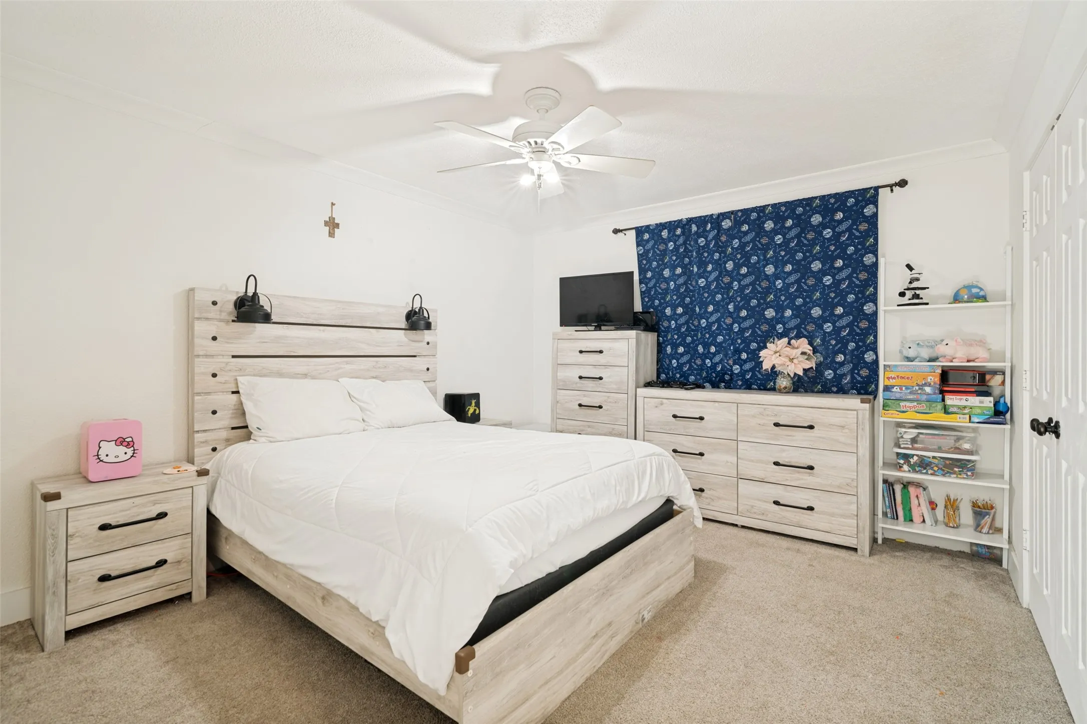 Secondary bedroom with a central ceiling fan, neutral carpet flooring, and double door closet.