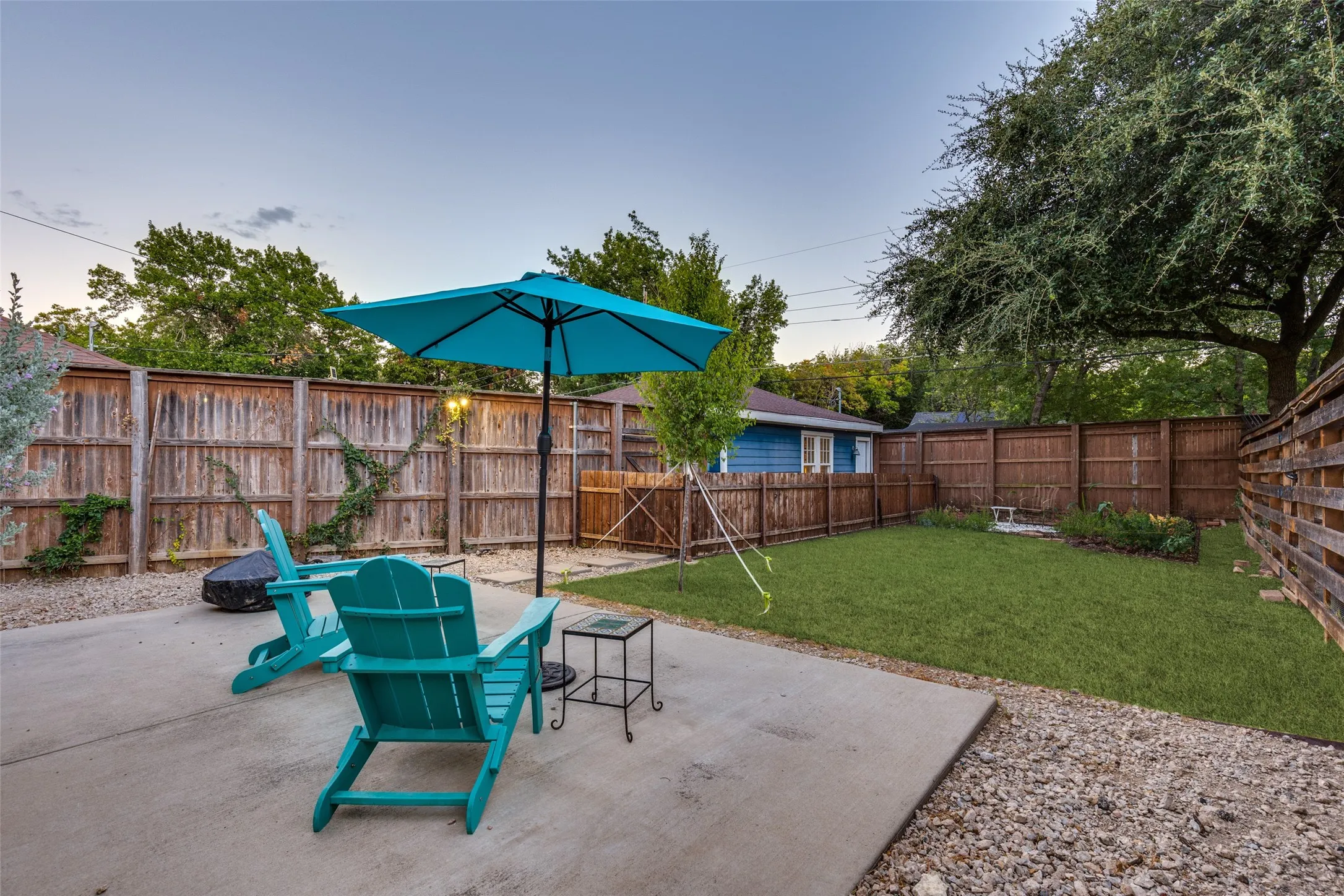 A fenced backyard combines generous lawn with patio space for a surprisingly versatile outdoor retreat.
