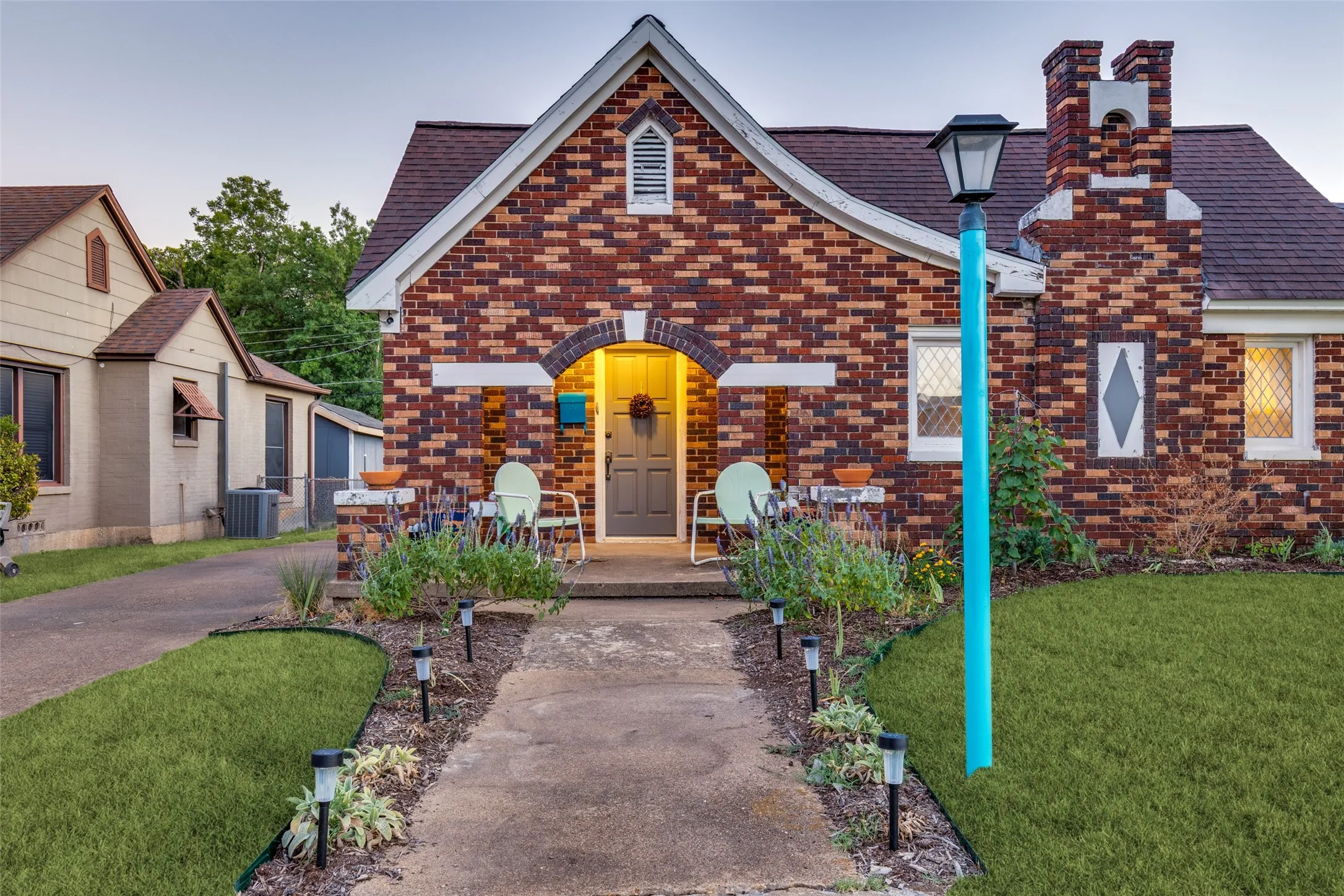 A closer look reveals the arched entry, original leaded-glass windows, patterned brickwork, and charming period details.
