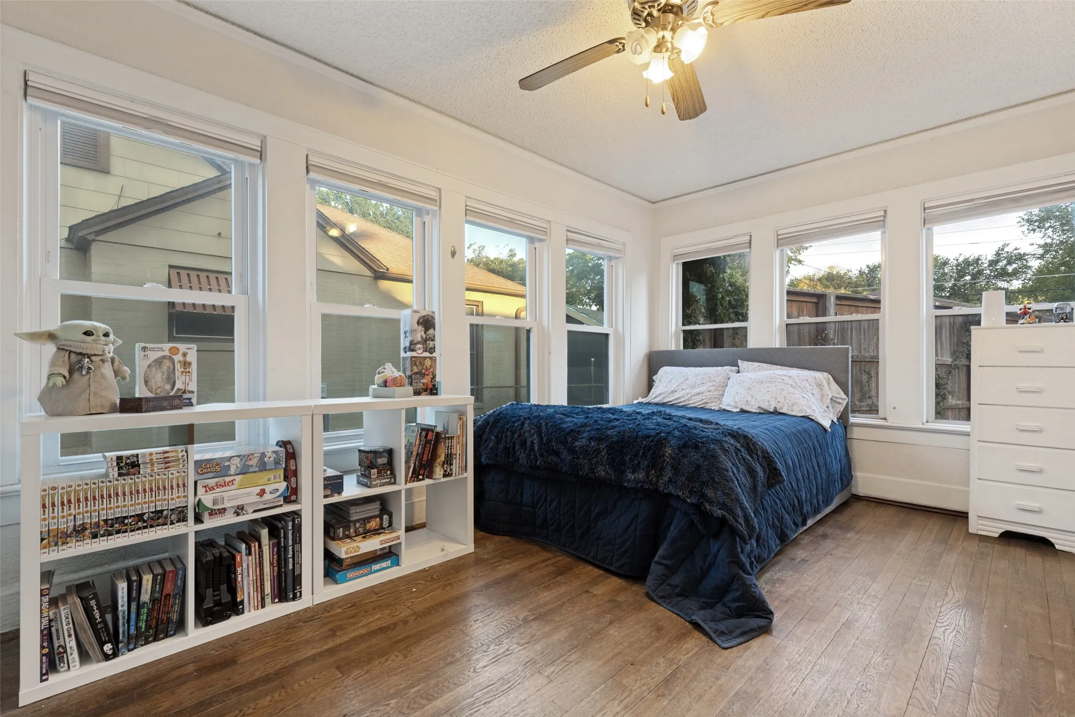 Wrapped in windows, Bedroom 1 pairs beautiful hardwood floors with built-ins and abundant natural light.