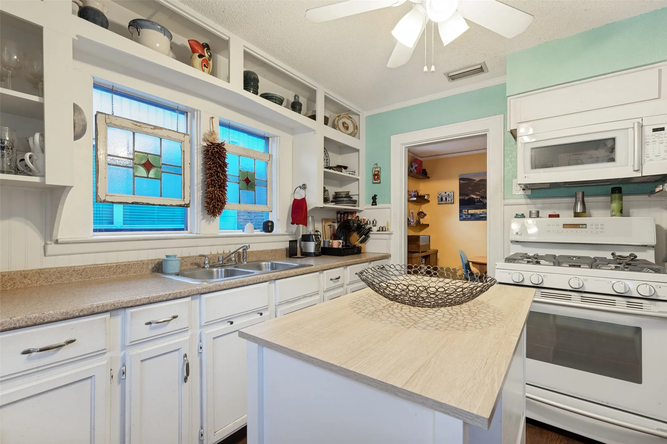 Personality meets practicality with generous counter space, plentiful storage, and a charming mix of open and closed cabinetry.
