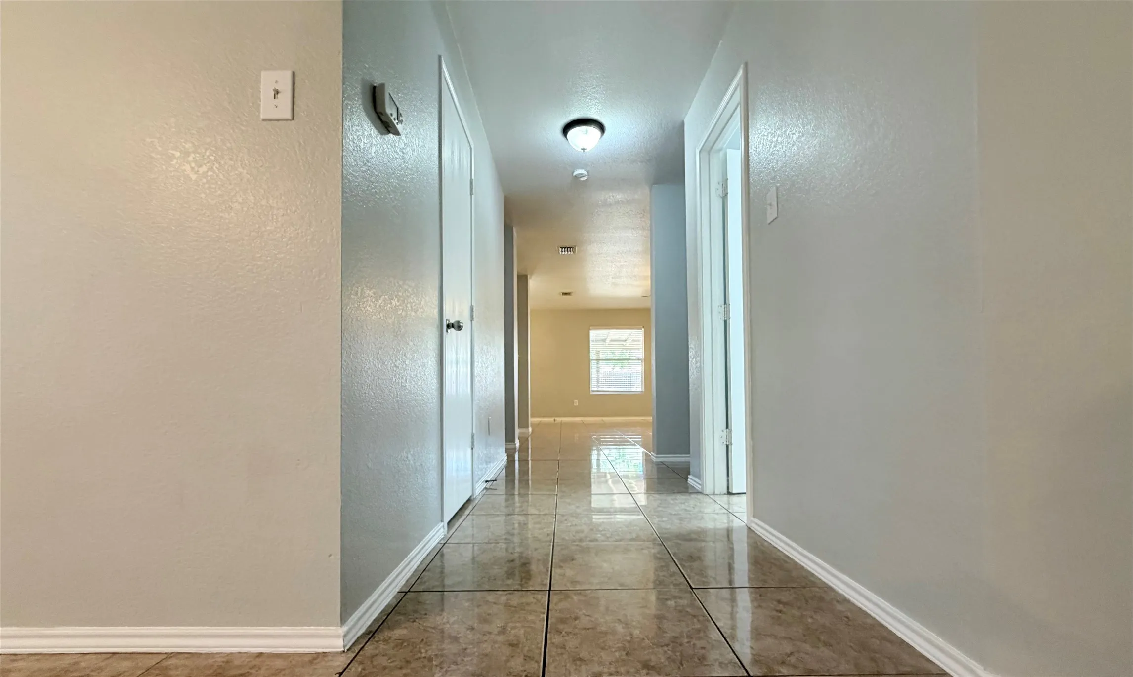 Hallway featuring tile flooring, neutral wall tones