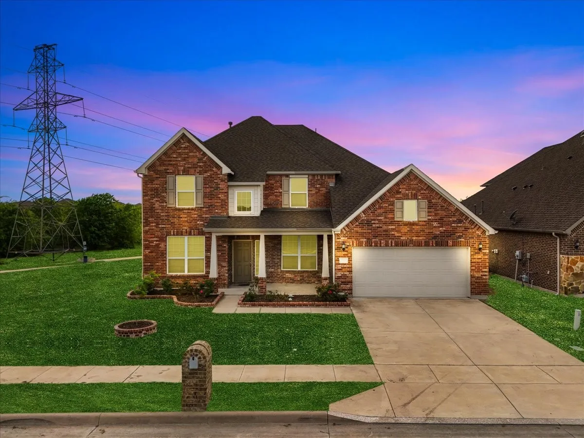 Red brick exterior with white trim, a covered front porch, an attached garage, and a concrete driveway