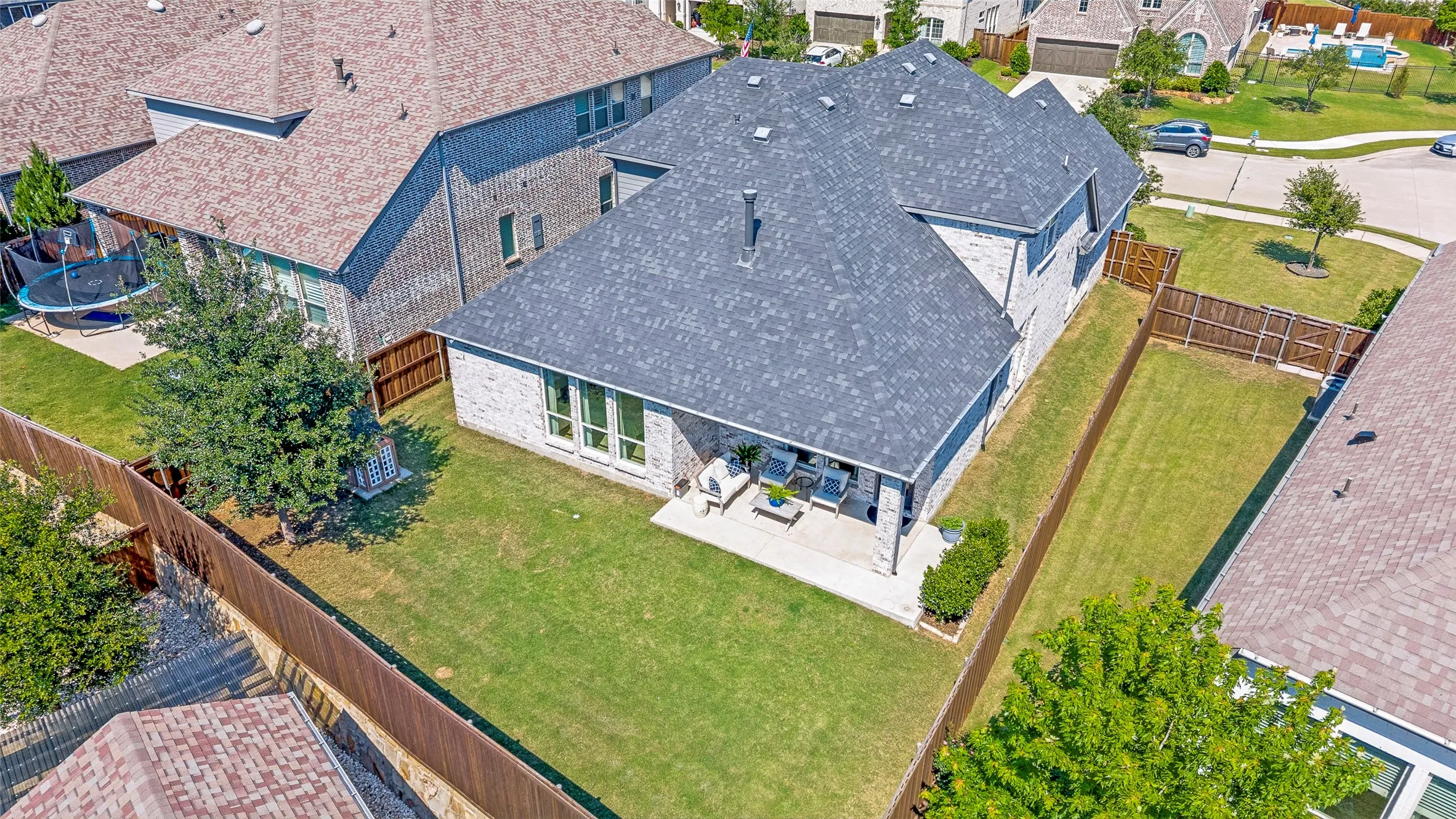 Rear elevation featuring a covered patio, fenced backyard, and a shingle roof