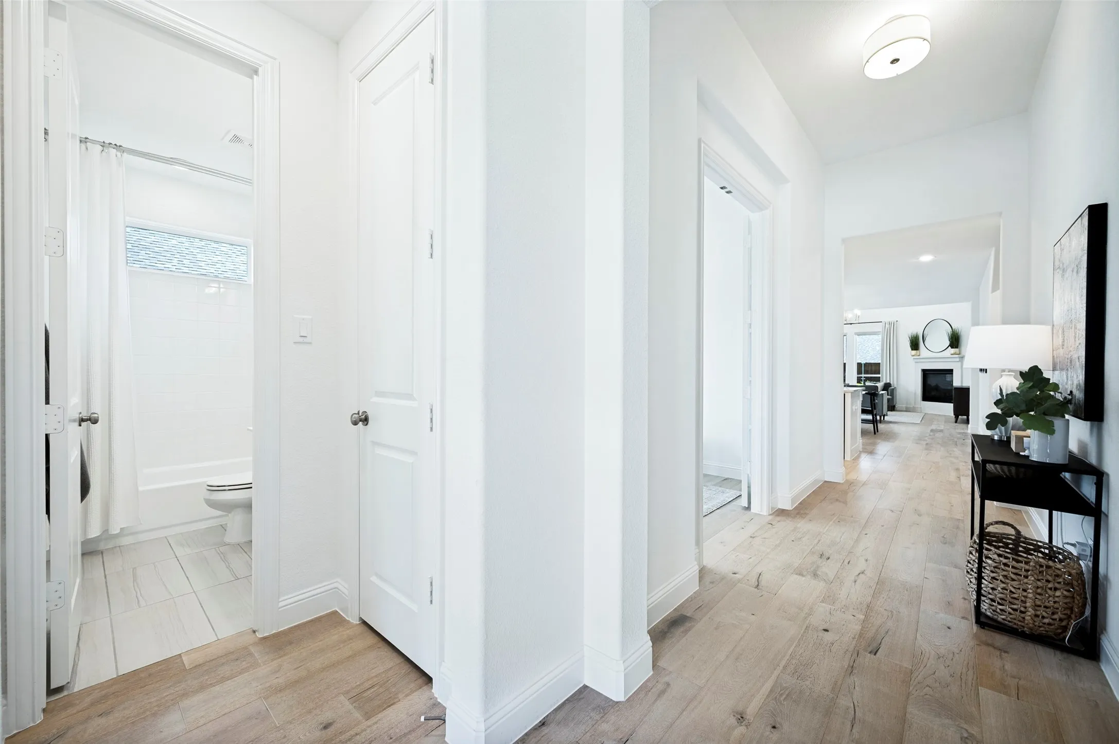 Wood-finish flooring throughout, bright white walls, and a recessed ceiling light fixture