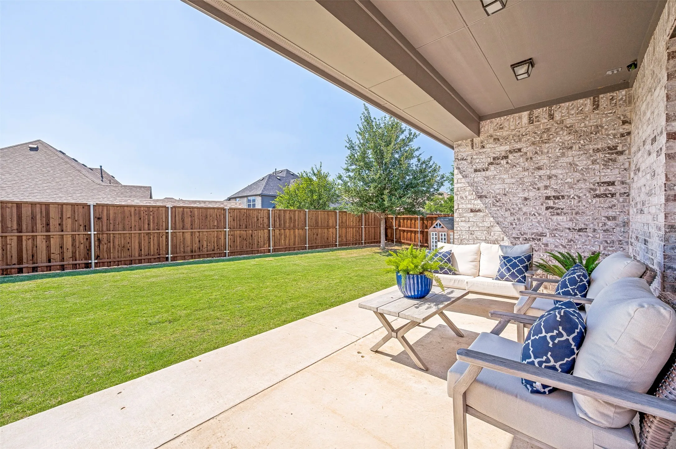 Covered patio with brick wall and concrete flooring