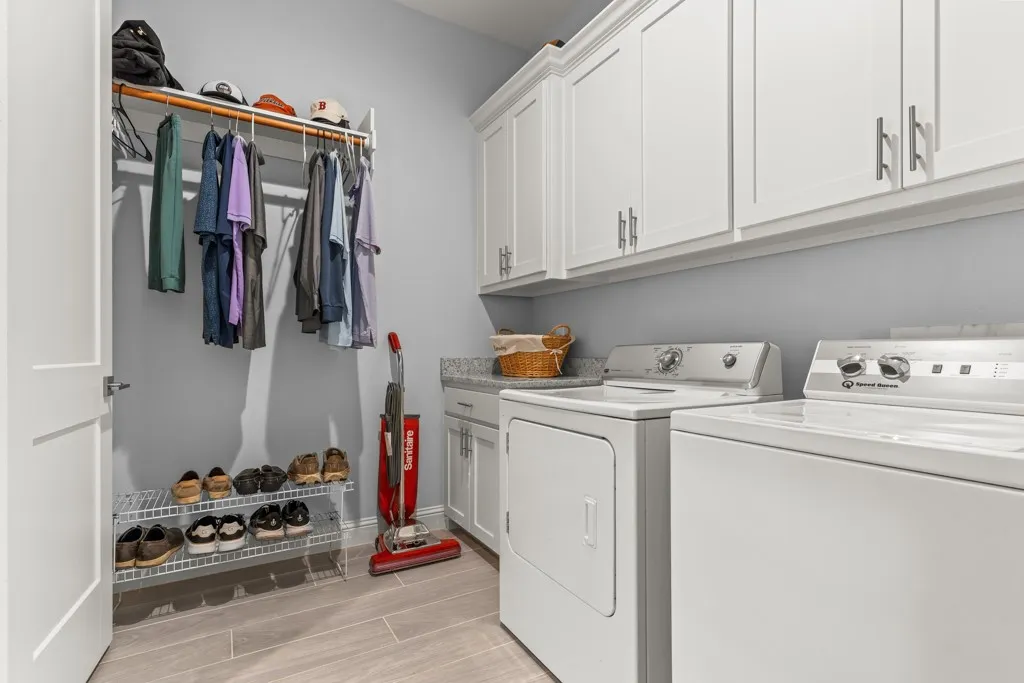 Built-in white cabinetry with brushed nickel hardware, light-toned countertop, and wood-finish flooring