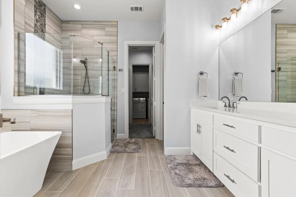 Dual vanity with white cabinetry and integrated sinks, gla