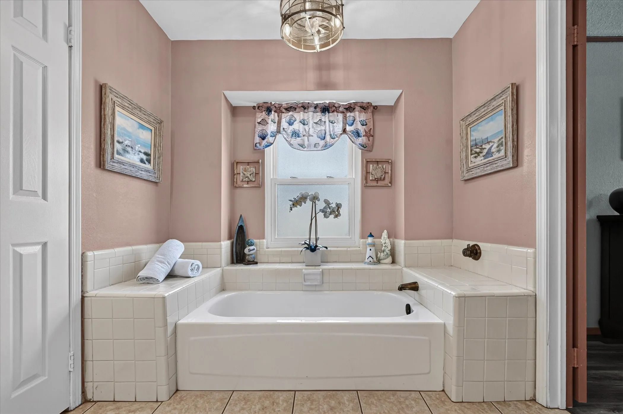 Primary bath features a spacious soaking tub framed by tile, with a recessed window bringing natural light into the​​‌​​​​‌​​‌‌​‌‌​​​‌‌​‌​‌​‌​​​‌​​ space.