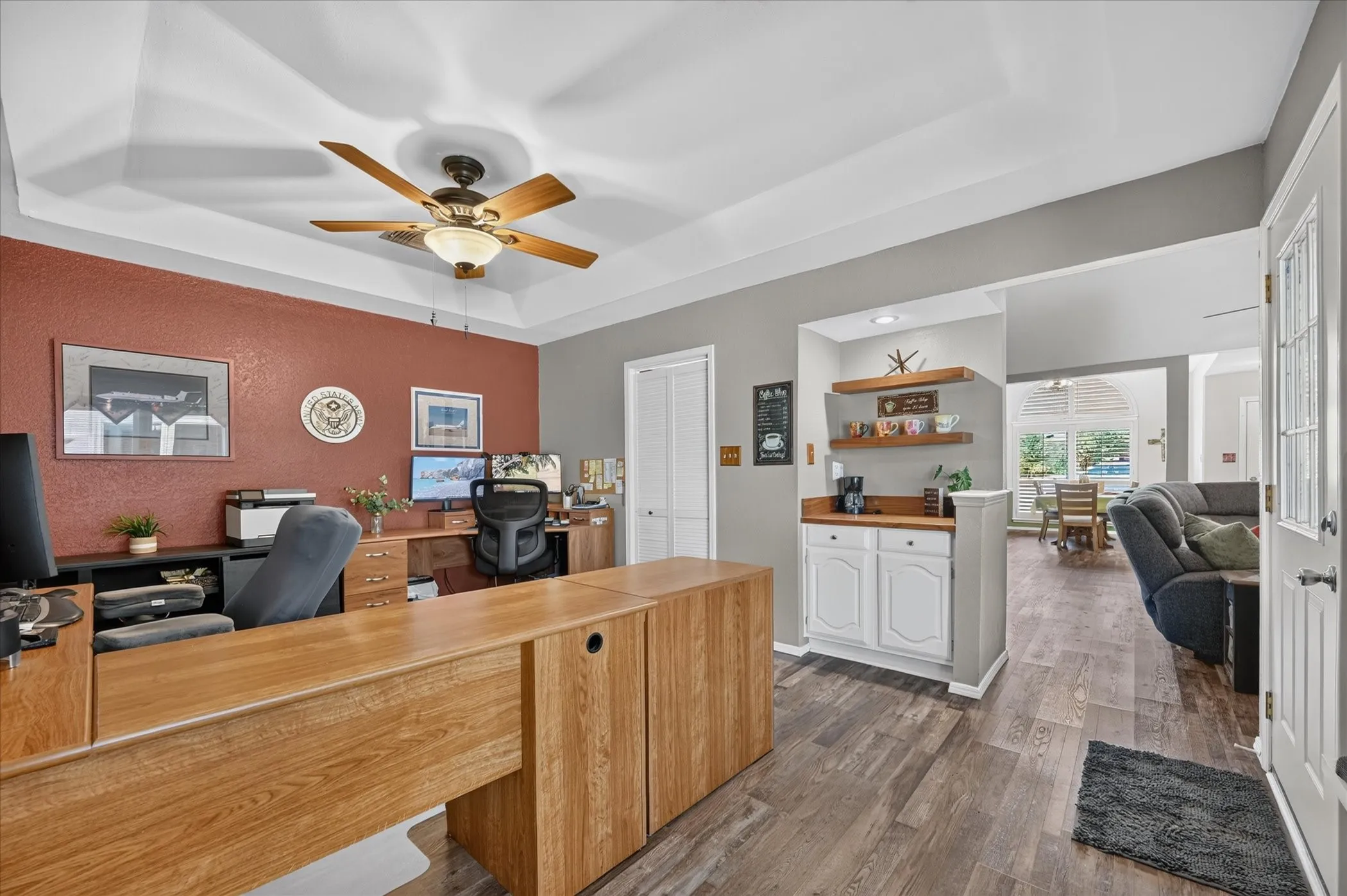 Well-appointed office offers excellent functionality with built-in cabinetry, floating display shelves, and convenient connectivity to the main living area.