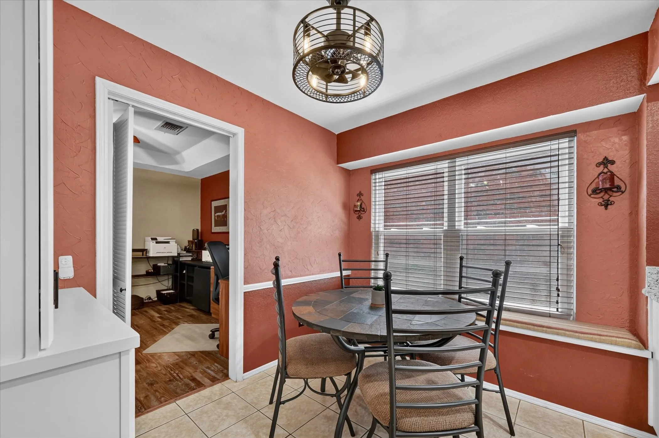 Intimate breakfast nook offers a cheerful setting for casual dining, highlighted by a broad window, decorative ceiling fixture, and easy access to the adjoining kitchen.