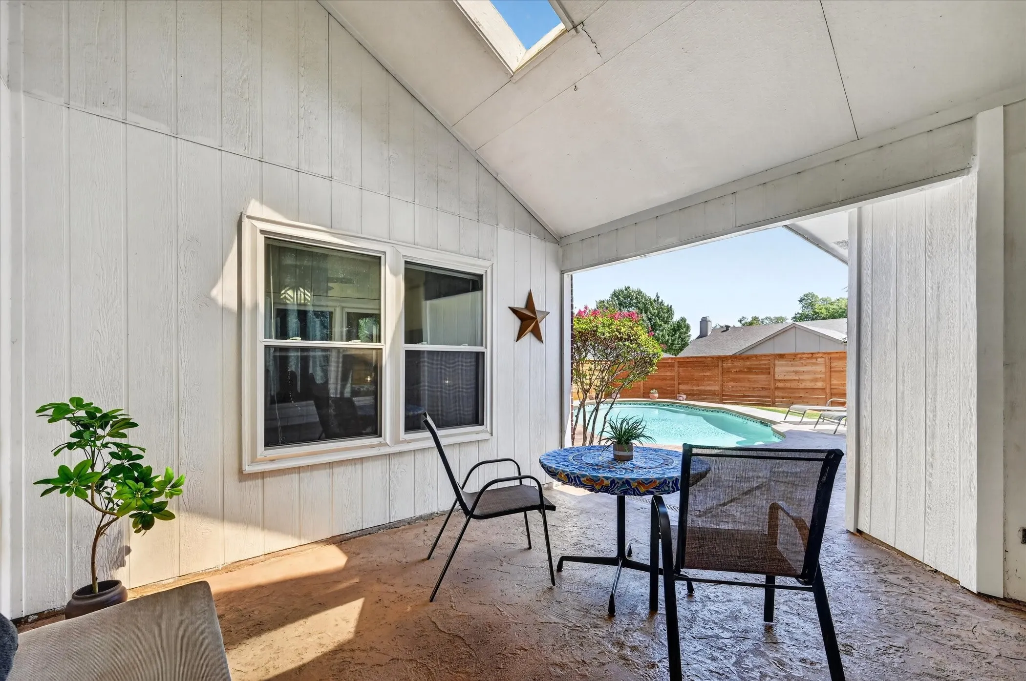 Covered backyard patio offers a shaded outdoor living area overlooking the swimming pool, with plenty of space for seating and entertaining.