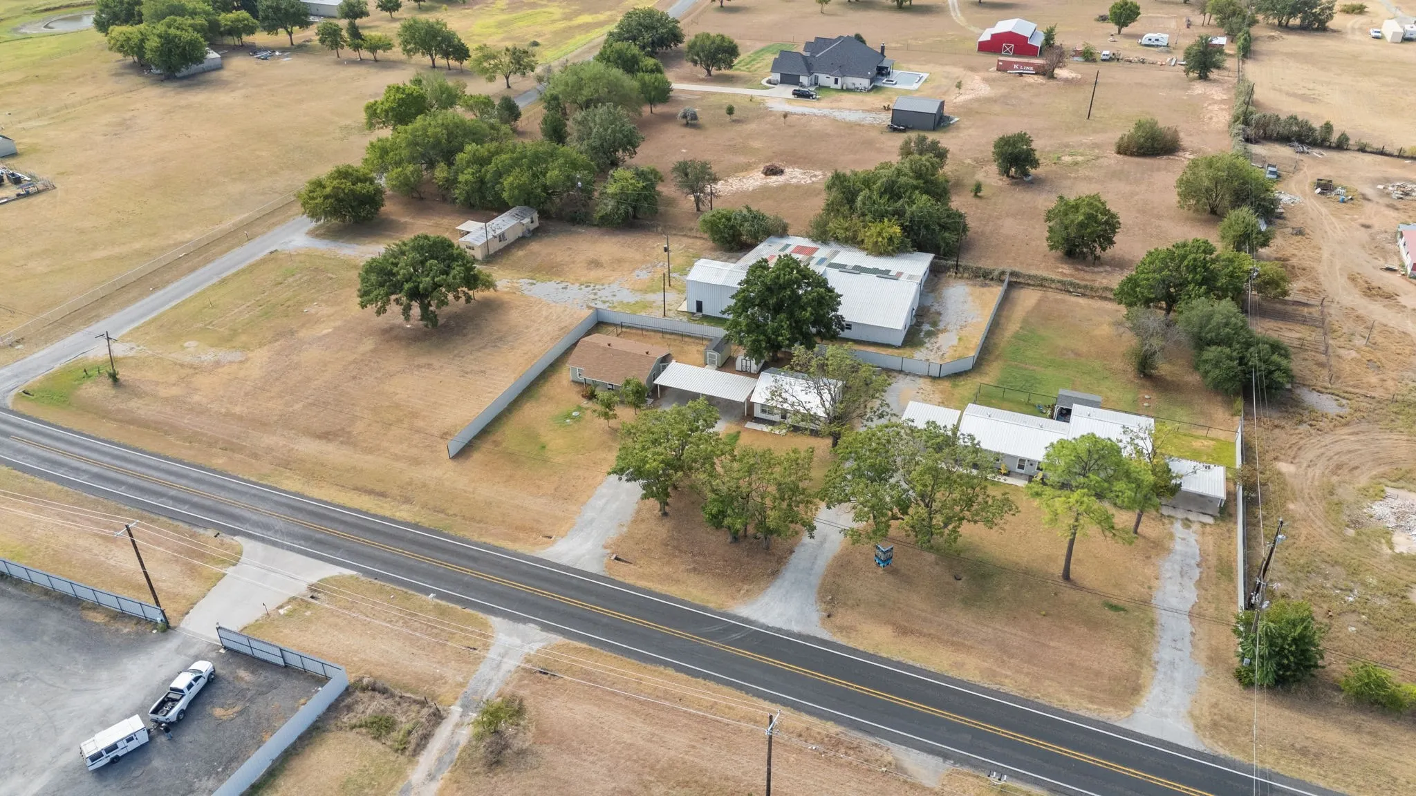 Aerial view highlighting the corner location, road frontage and overall site layout.