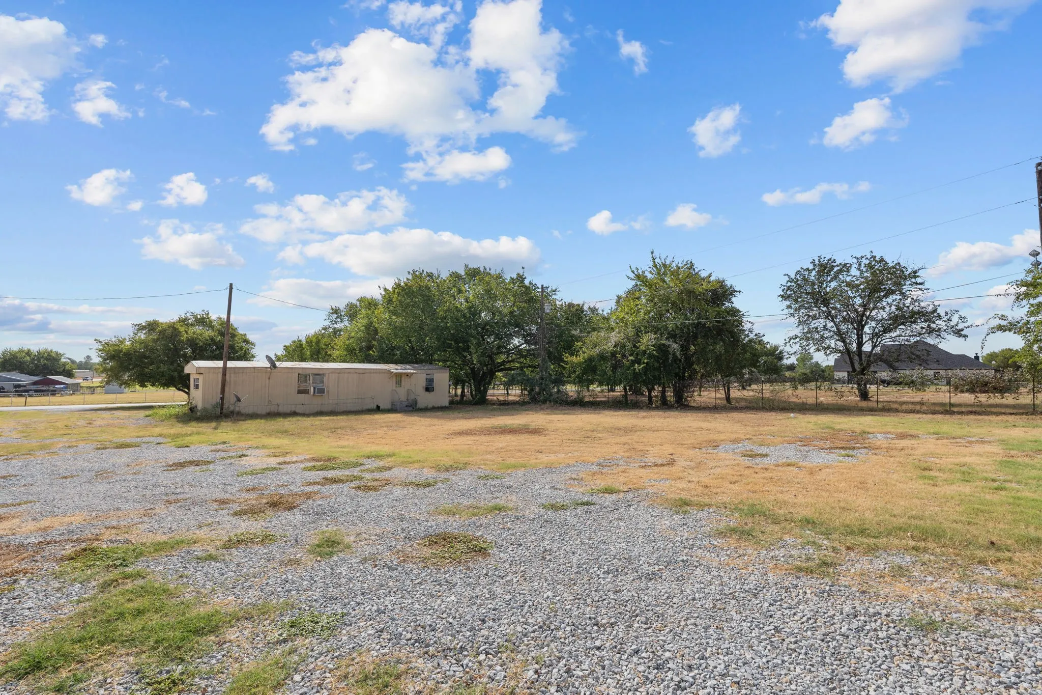 Additional open gravel and yard area offering flexible space for storage, staging or operations.