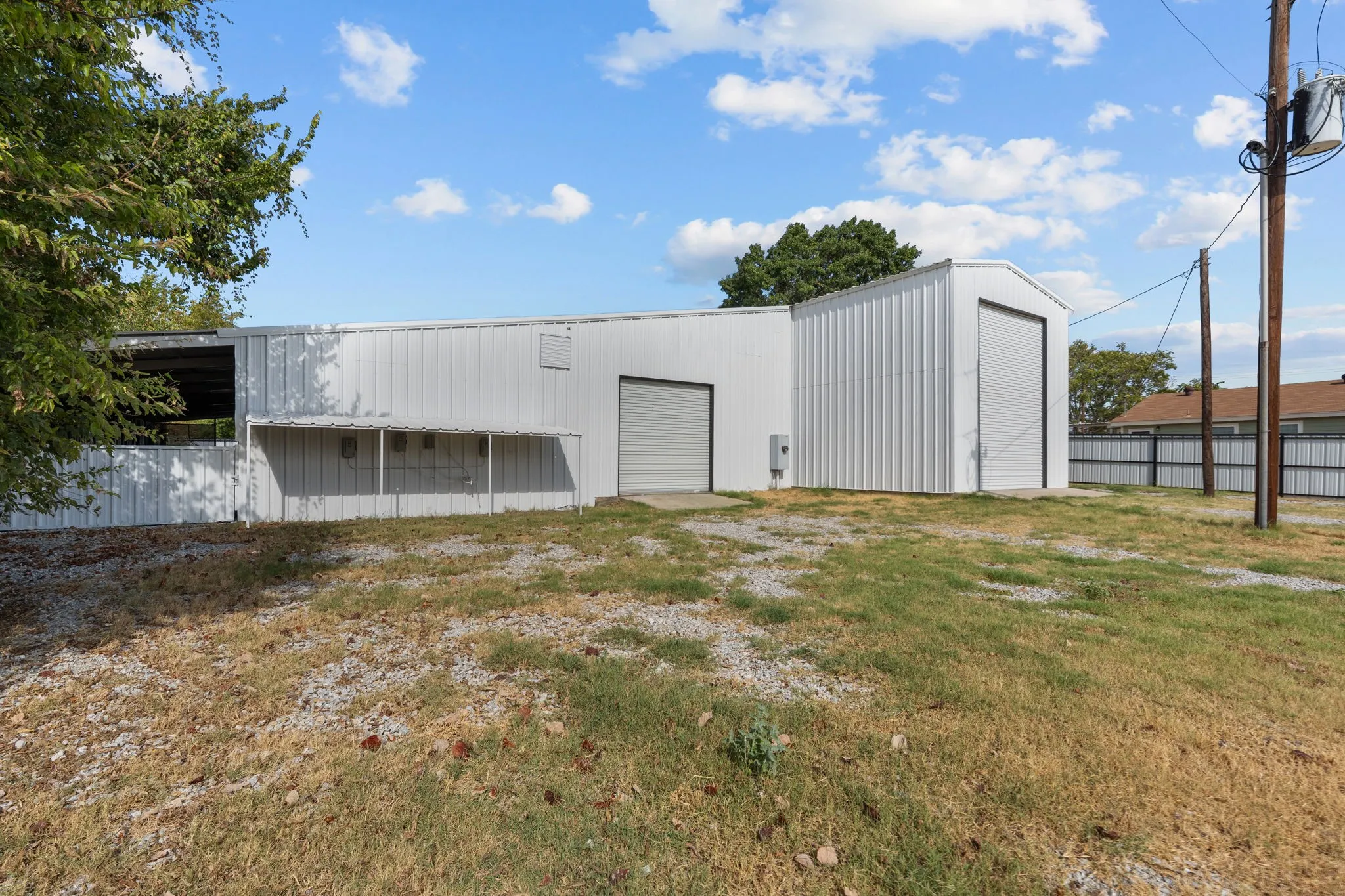 Additional exterior view of the existing commercial building and surrounding yard.