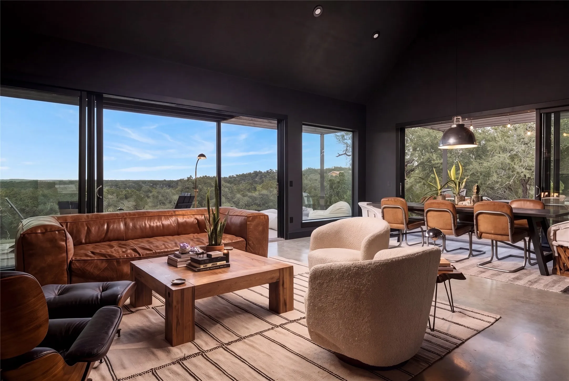 Soaring vaulted ceilings and concrete flooring anchor this dramatic open-concept living space with sweeping views.