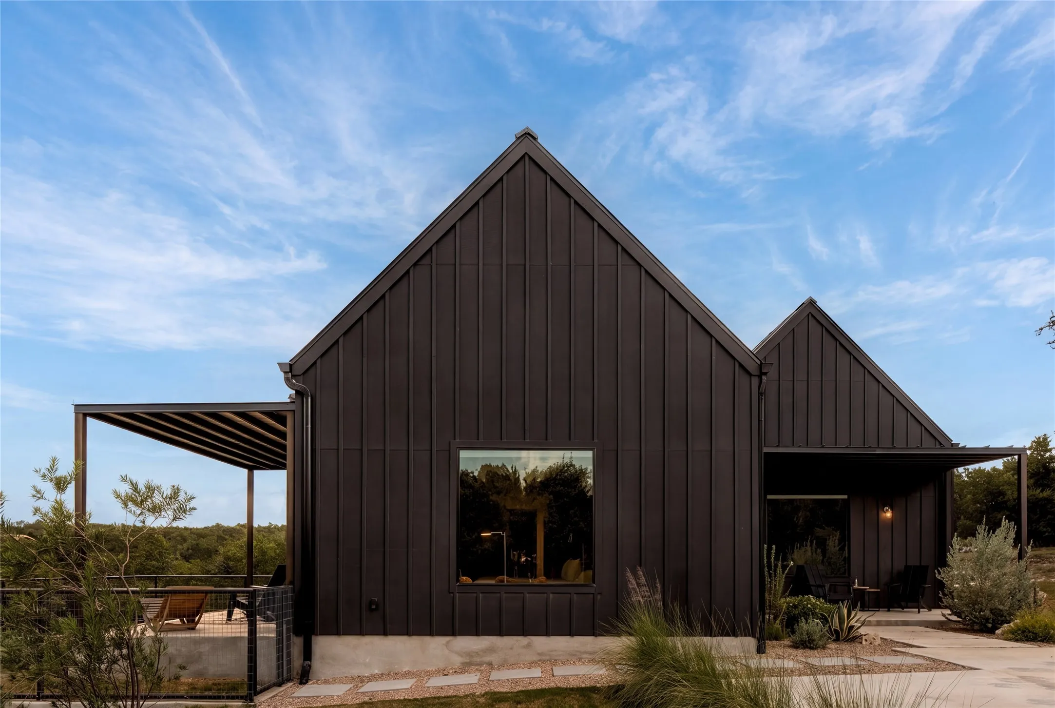 Architecture with conviction - black board-and-batten under Texas blue skies.