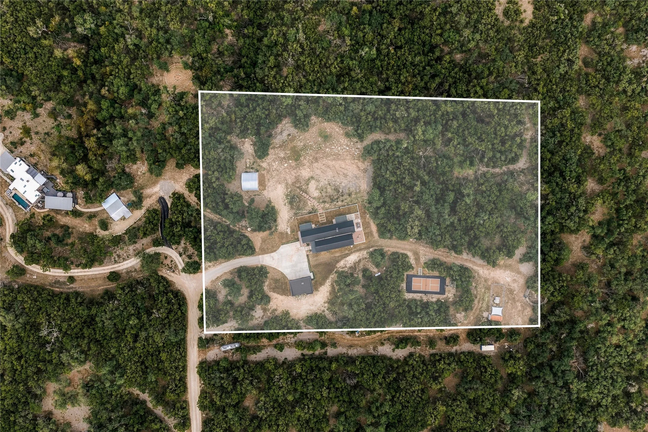 Densely wooded acreage surrounds the private home site, visible from this overhead perspective.
