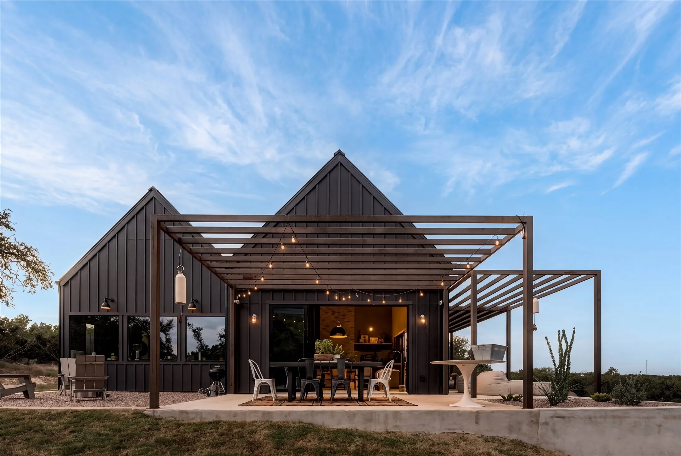 Soaring vaulted ceilings and concrete flooring elevate this modern dining space with sliding glass doors.
