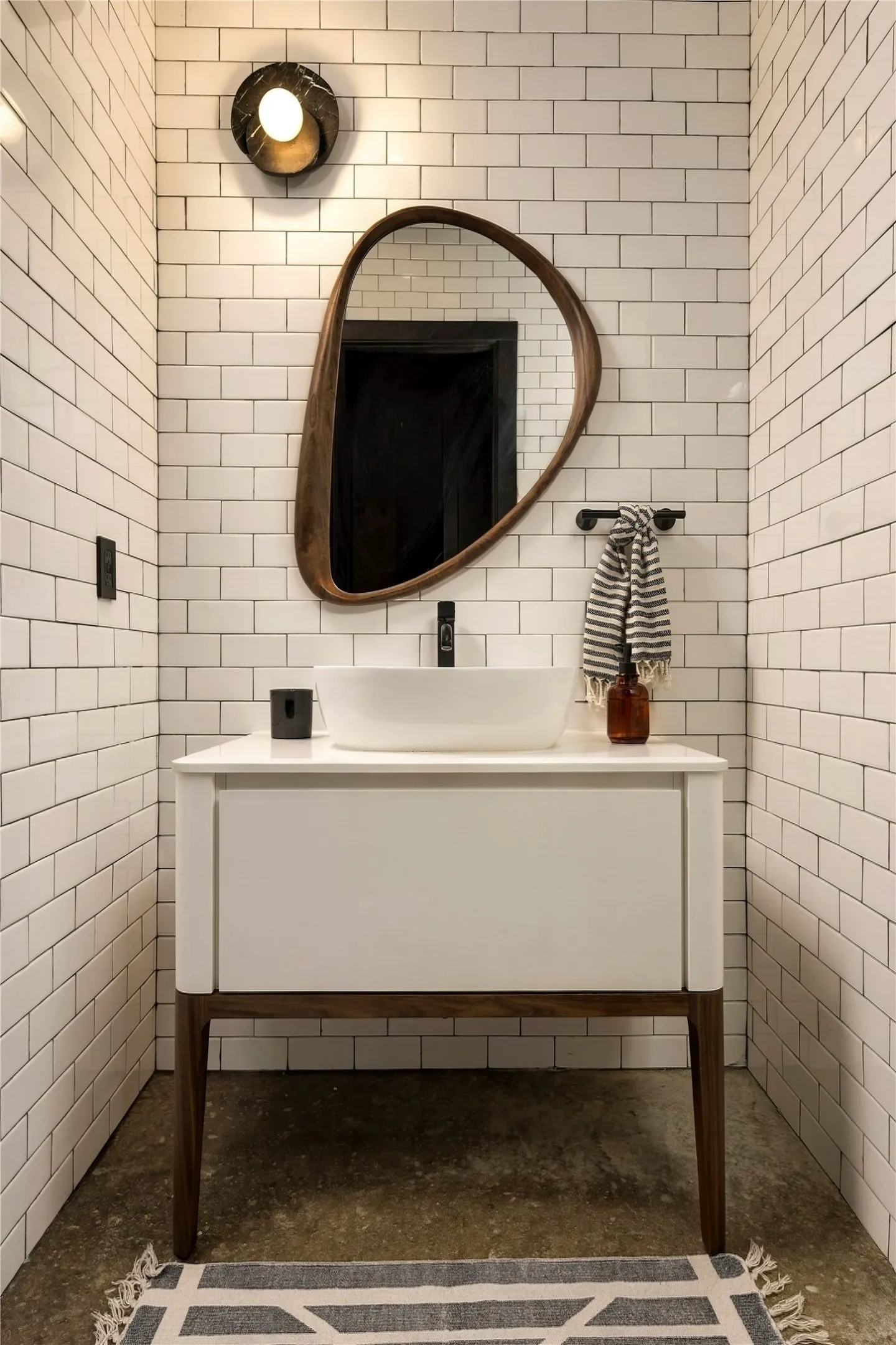 Crisp subway tile walls and a modern floating basin vanity anchor the hall bath.