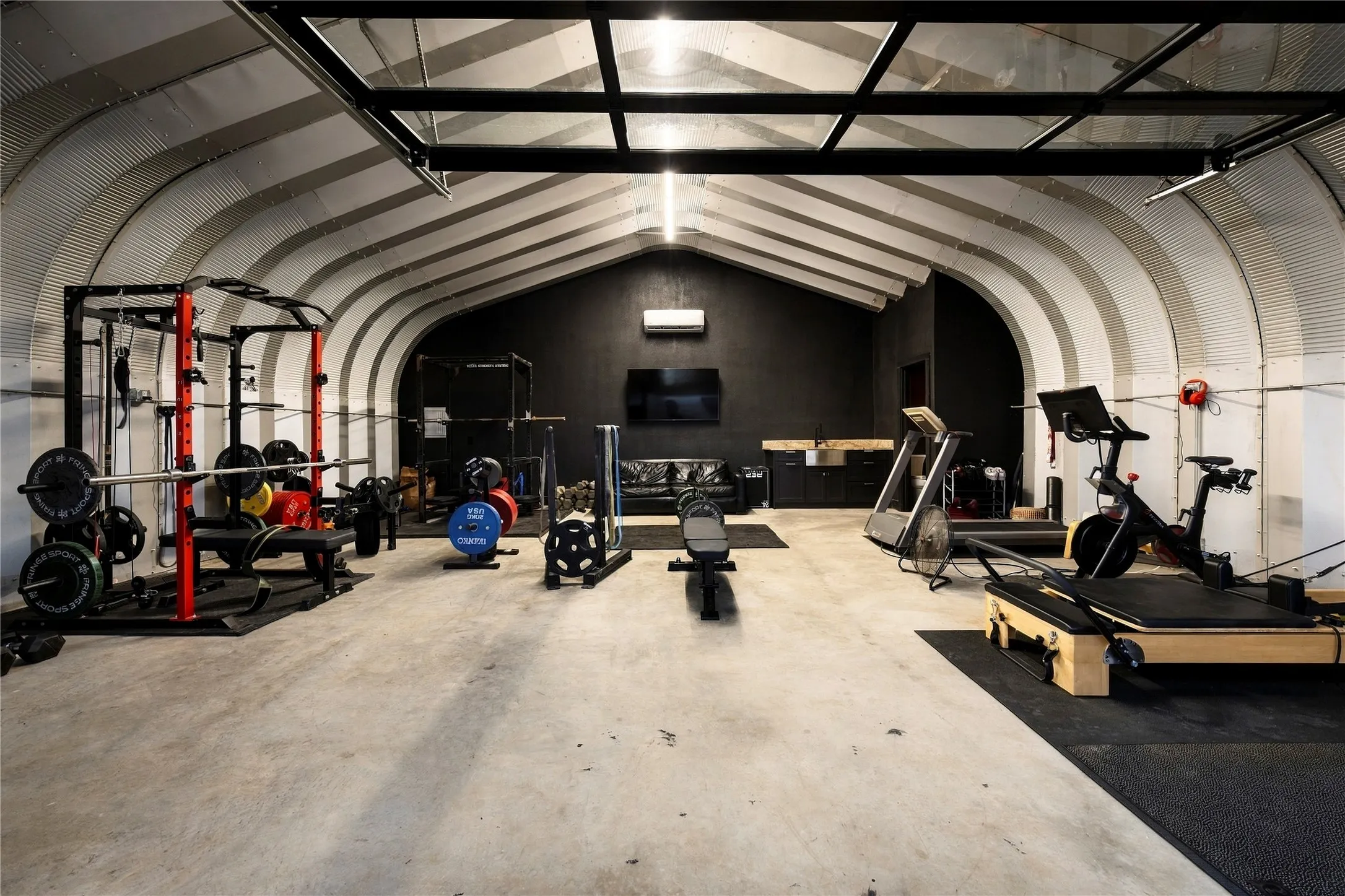 The Quonset hut is currently used as a spacious gym complete with a mini-split, bar and half bath.